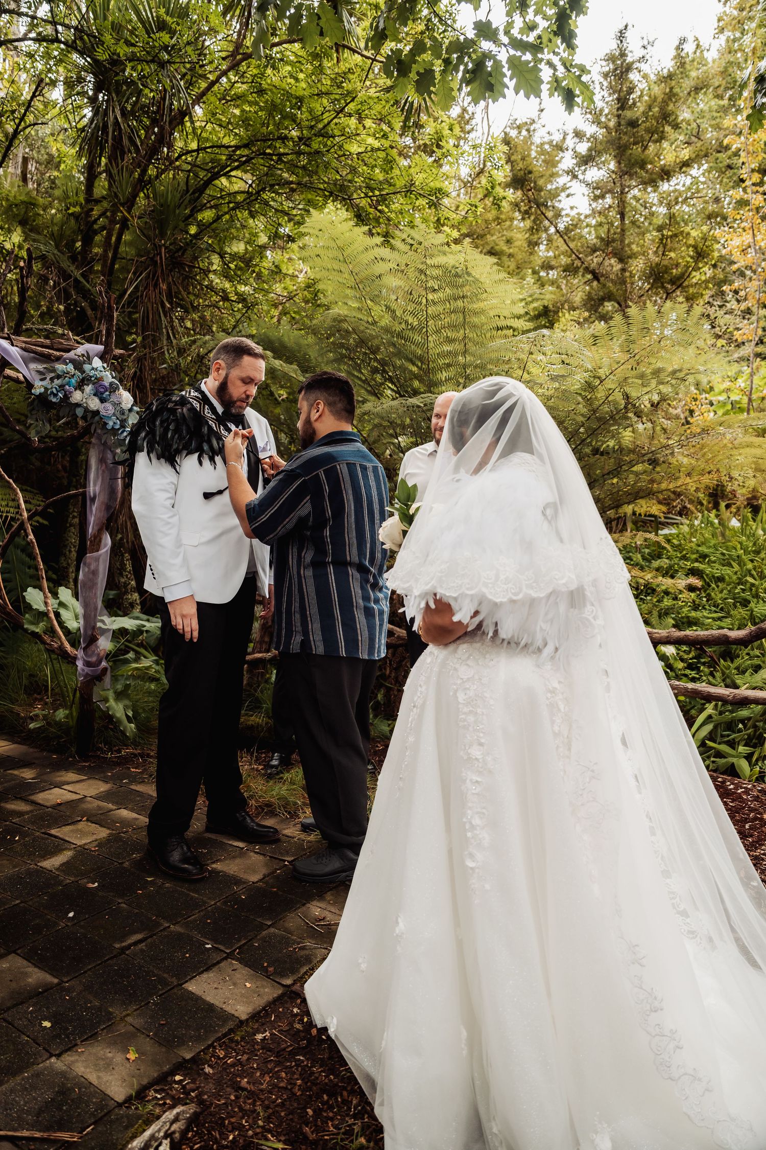 Bride and groom exchange vows with officiant in a lush garden wedding ceremony.
