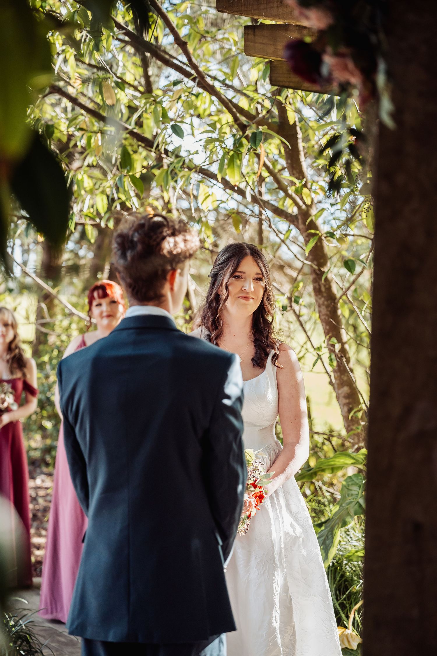 Bride and groom exchange vows in romantic outdoor garden wedding ceremony.