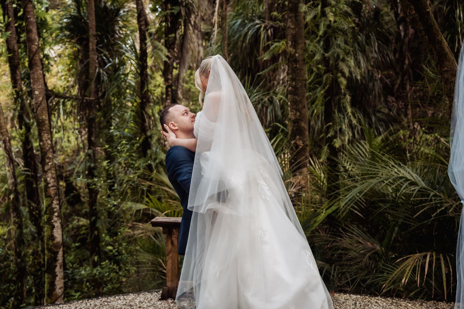 Romantic wedding portrait session in front of a rustic white chapel surrounded by trees.