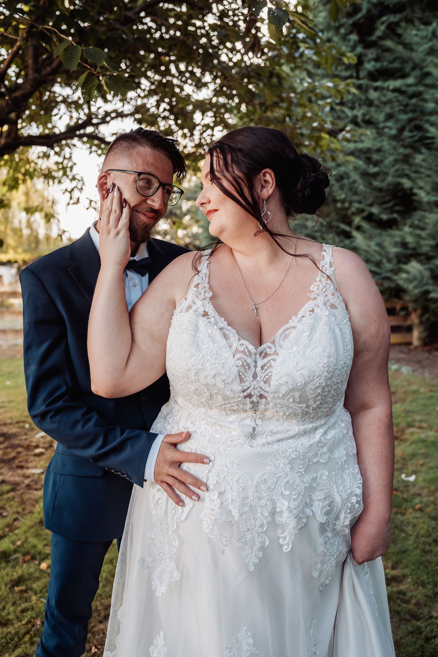 Candid portrait of a couple sharing a tender moment during their outdoor wedding photoshoot.