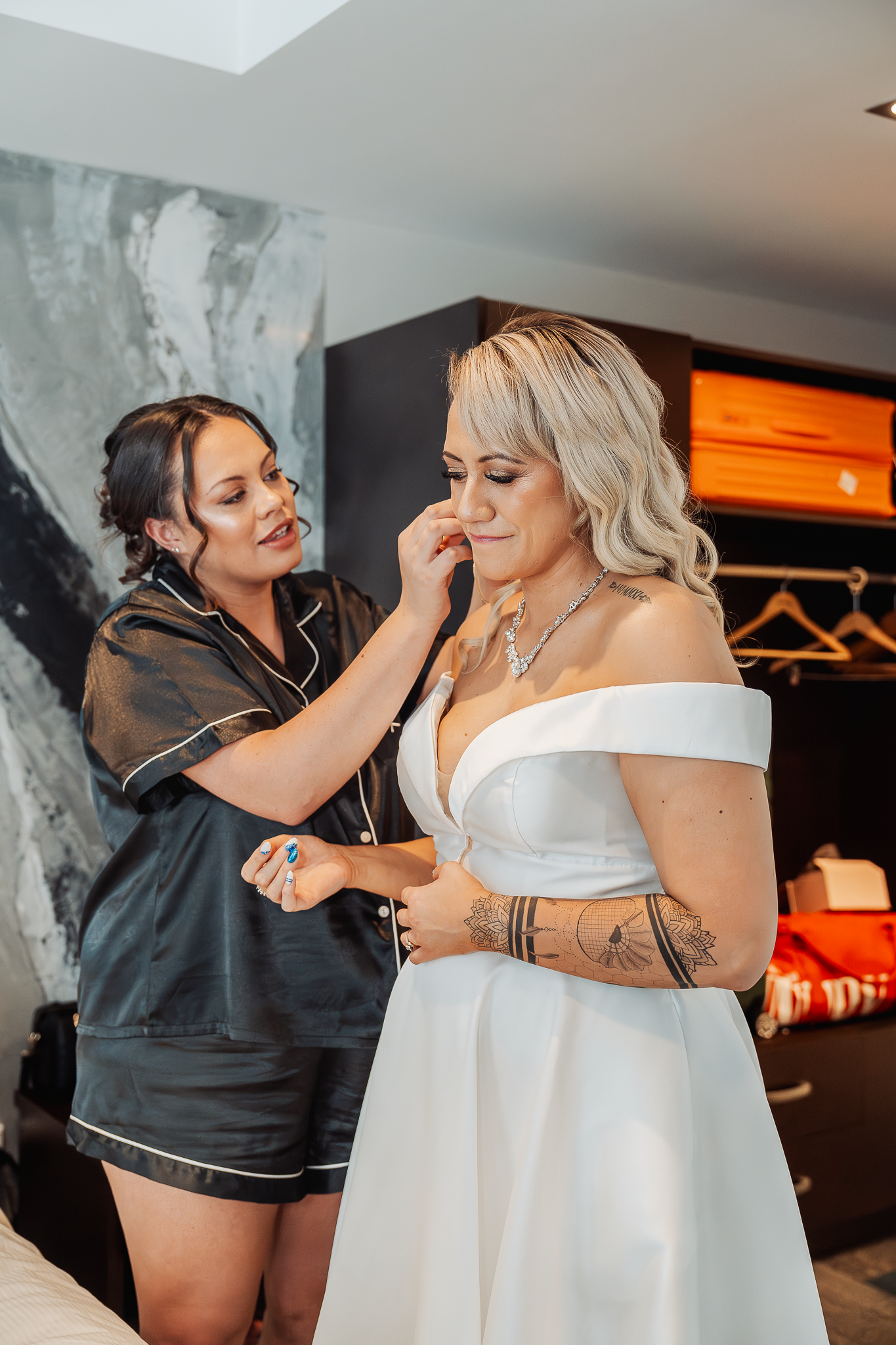 Stylist making final adjustments to bride's hair and accessories before wedding.
