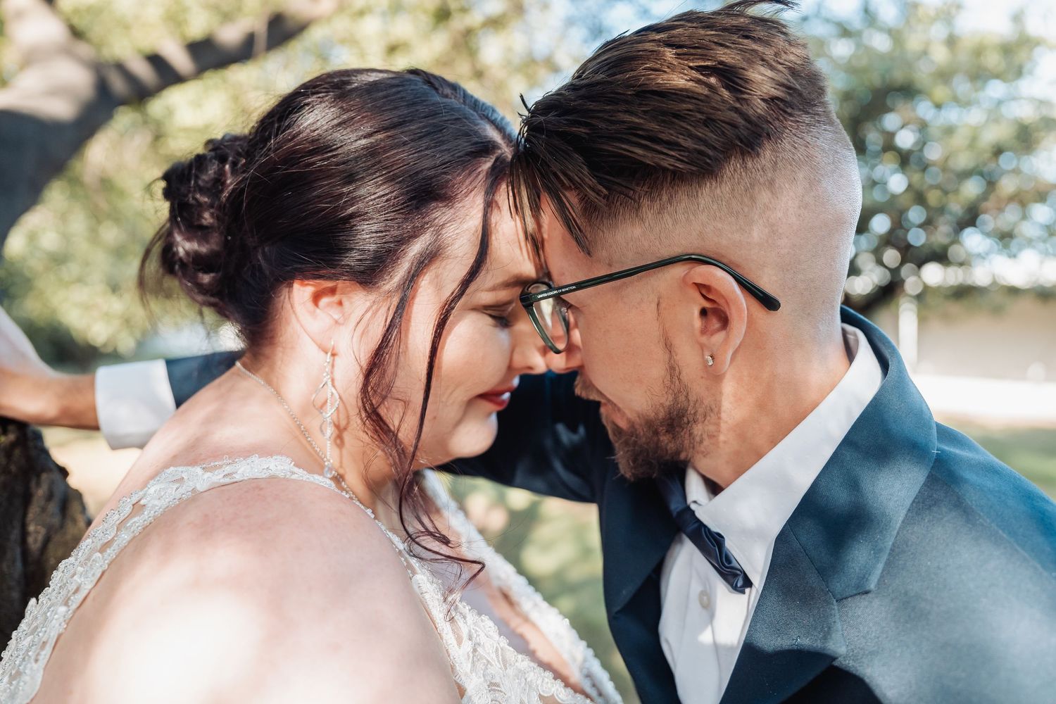 A tender romantic moment shared between newlyweds outdoors.