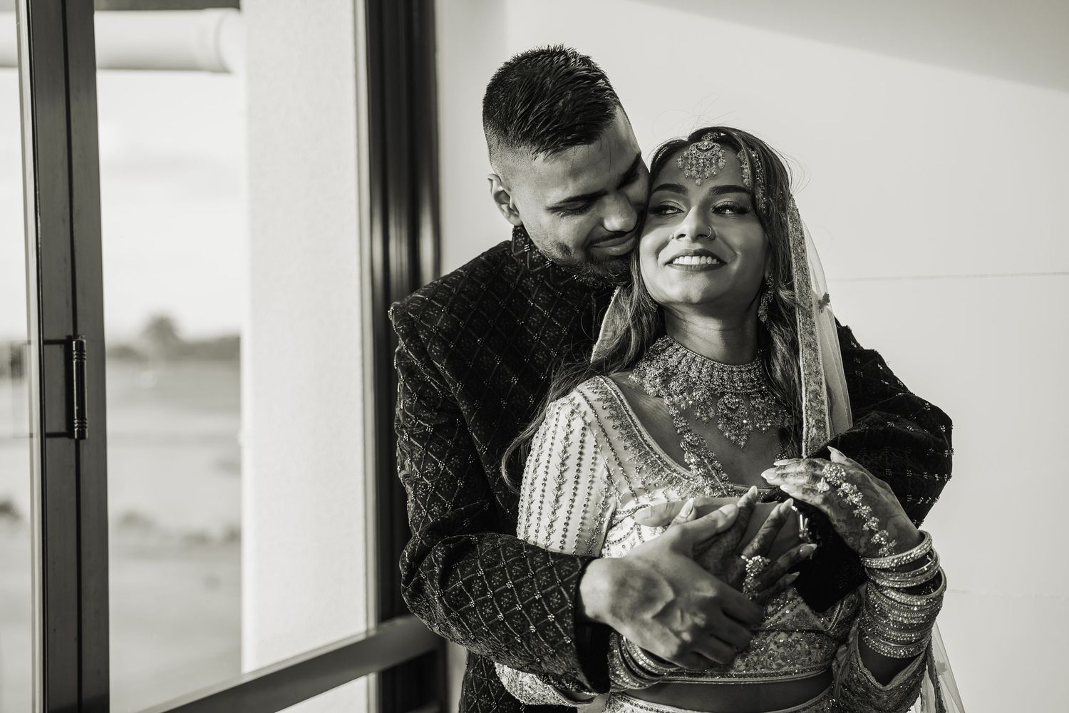 Black and white candid moments of a couple by a window.