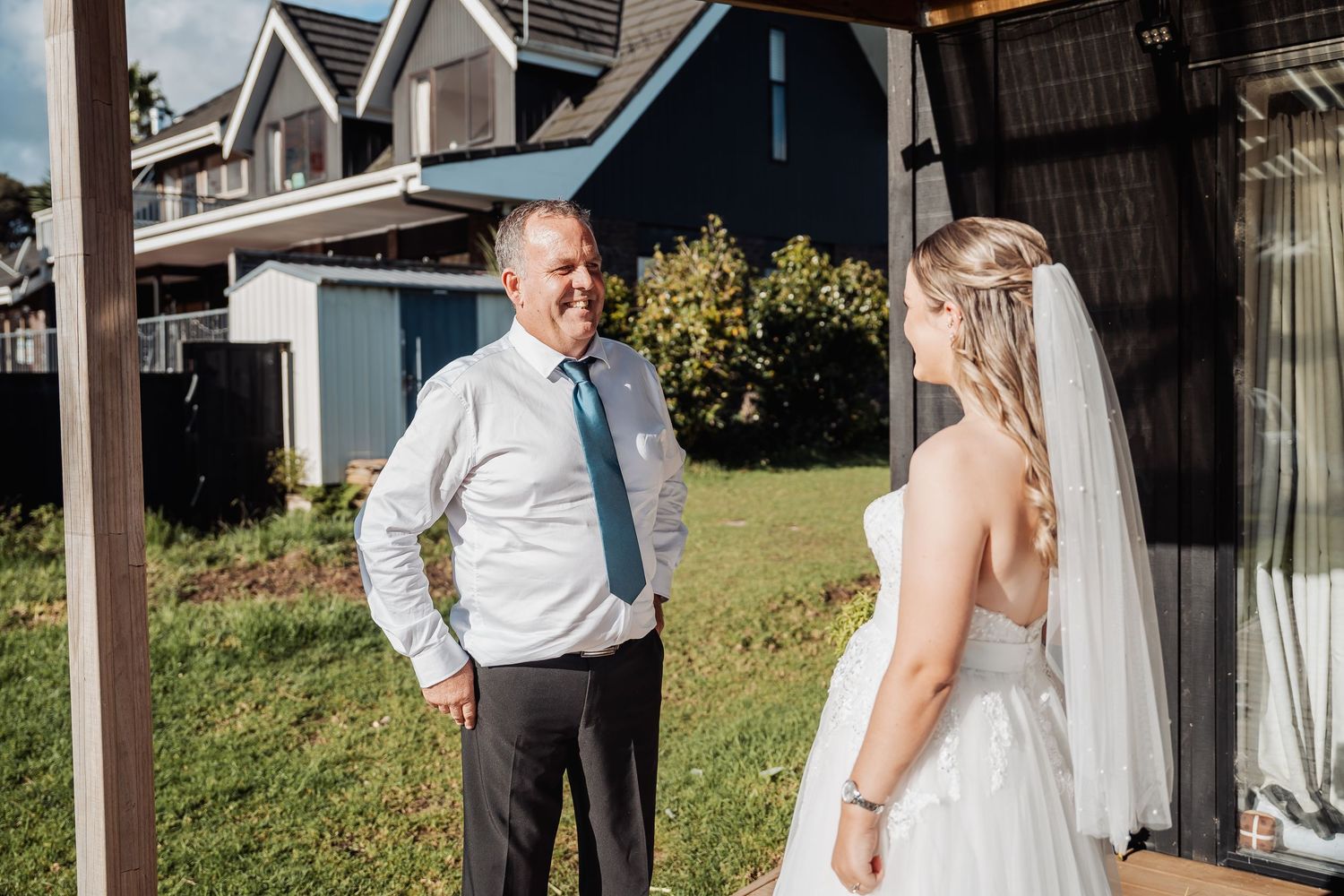 Romantic outdoor first look moment between couple on their wedding day, bathed in natural sunlight.