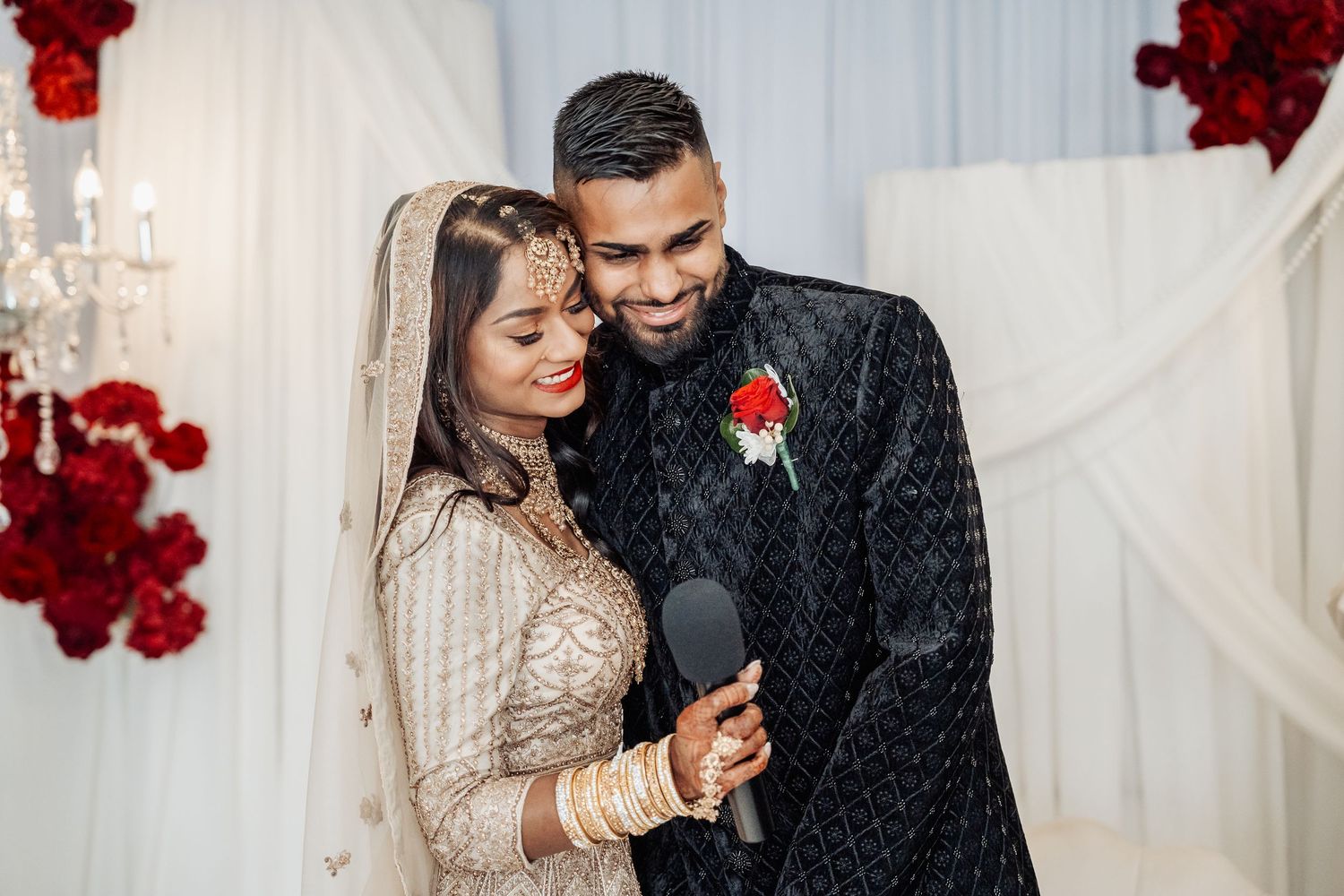 A romantic scene with red rose decorations and white draping in the background.