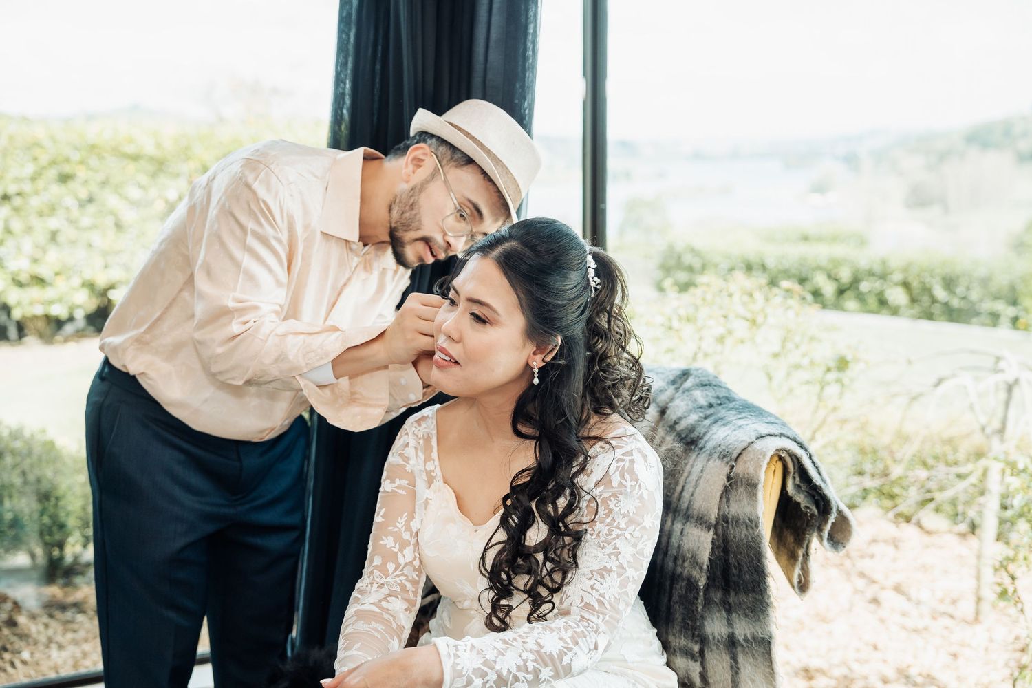 Romantic couple shares intimate moments in an outdoor setting wearing elegant white and cream attire.