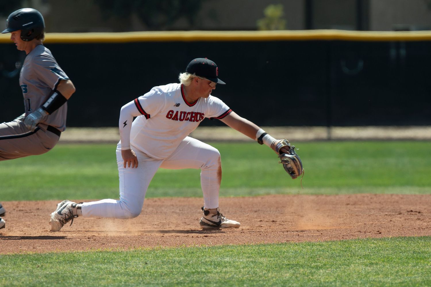 Baseball player catching a ball in a lunge.