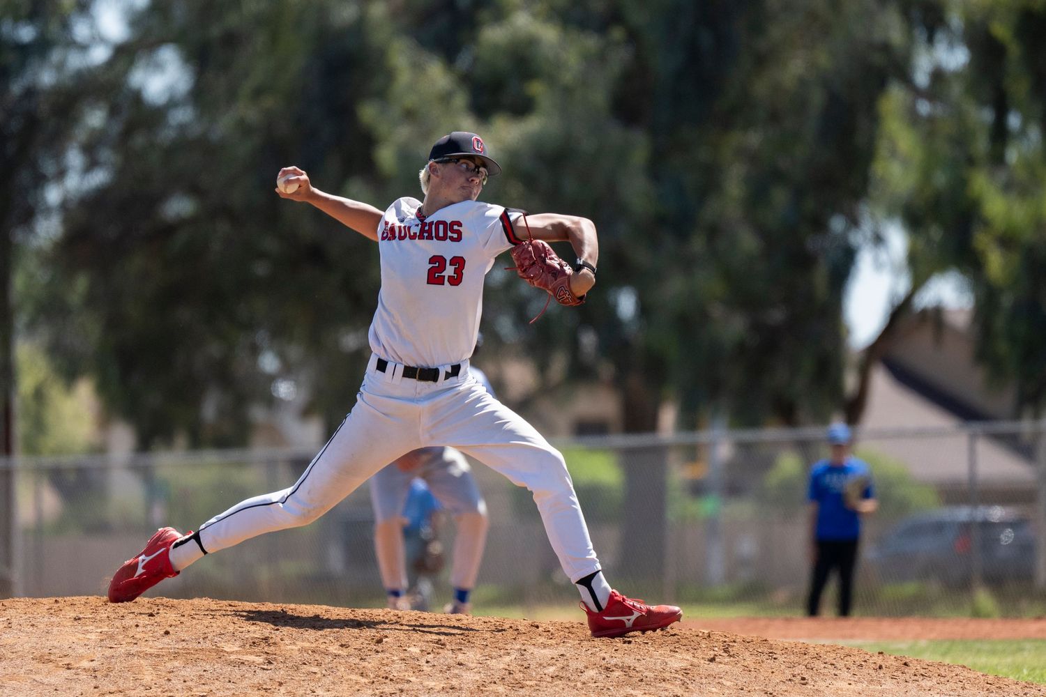 Baseball player pitching a ball on the mound.