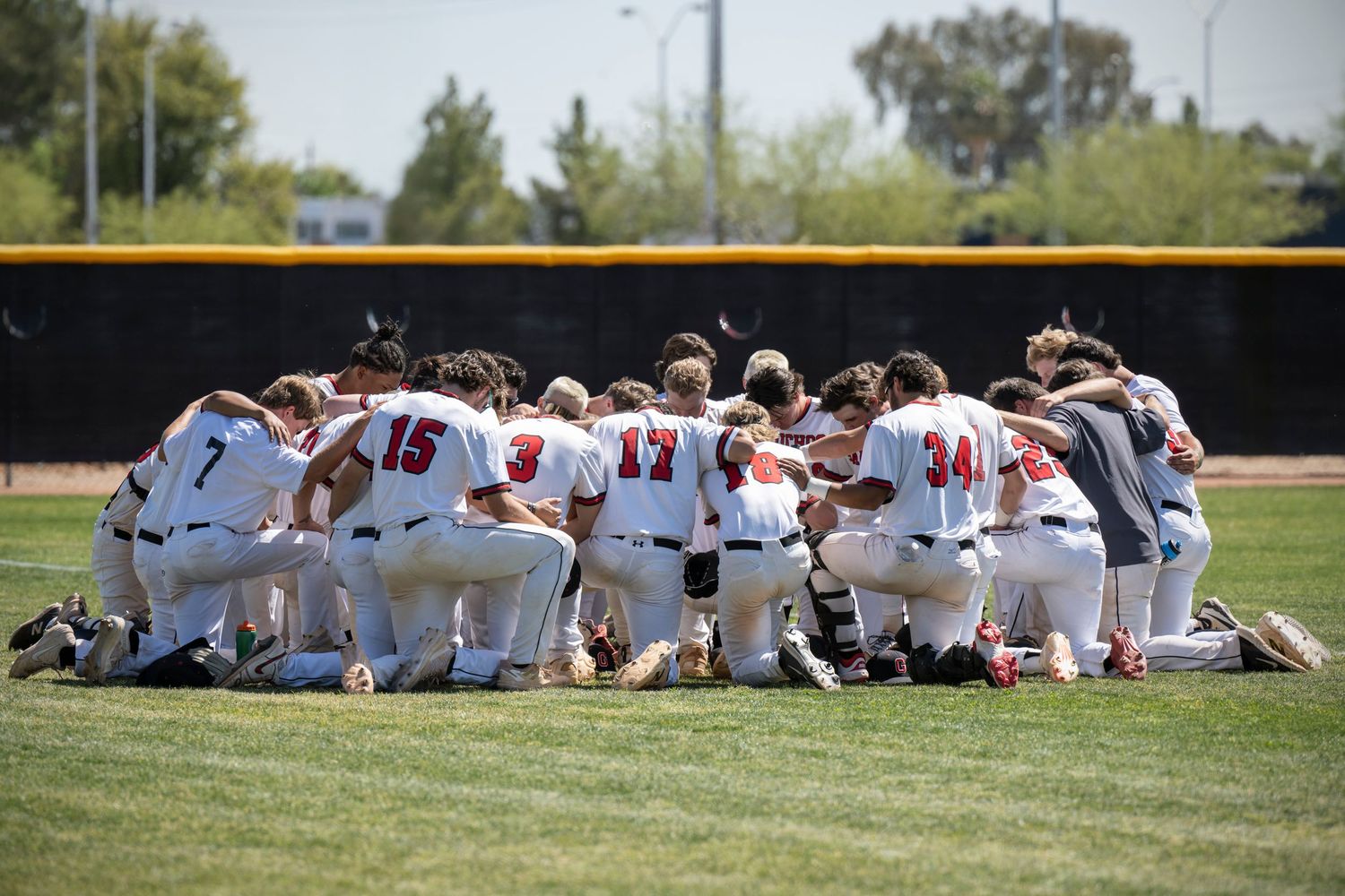 GCC Baseball team prayer huddle before game.