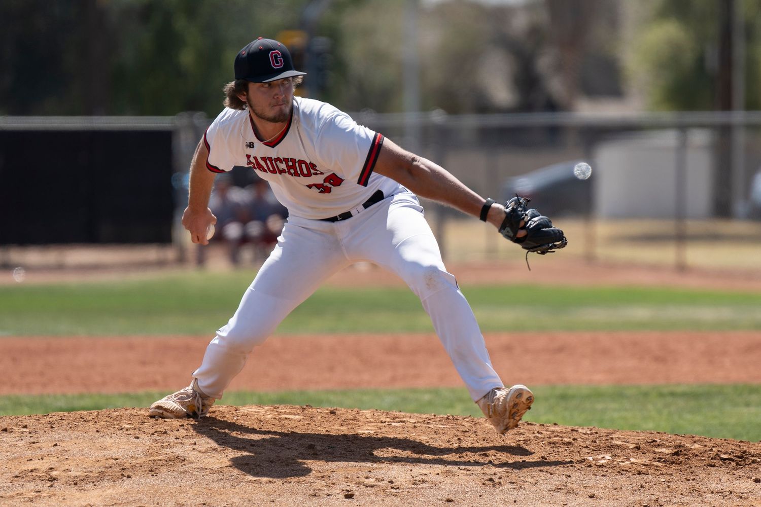 Baseball player throwing a pitch on the mound.