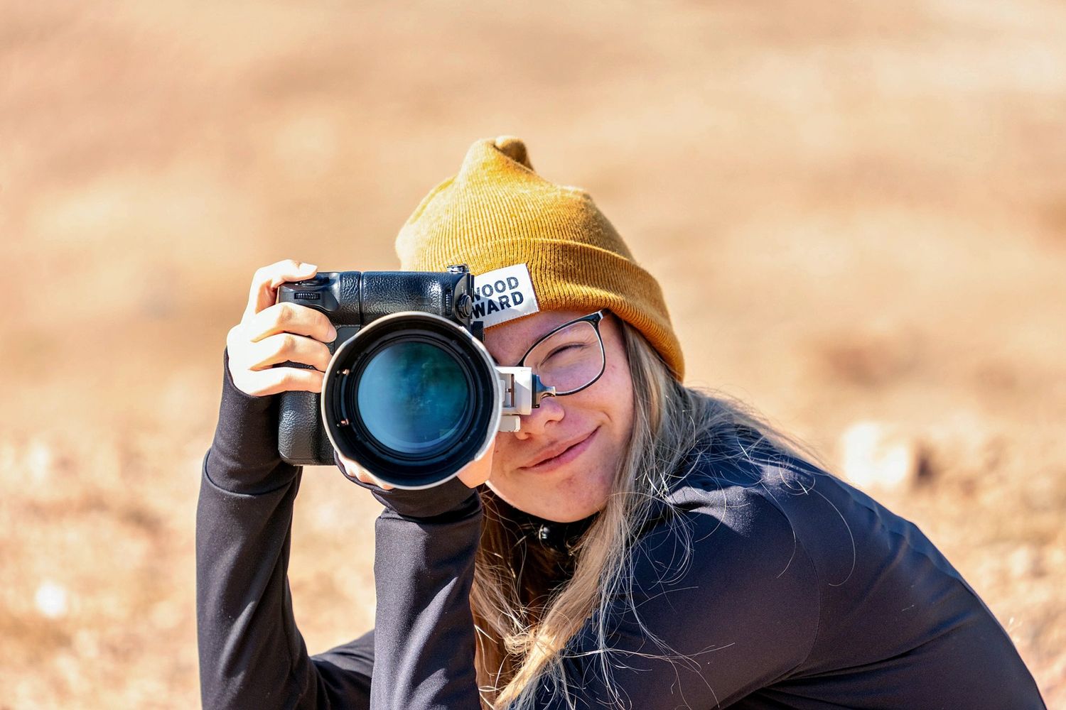 Owner of Danielle Gantt Photography holding a camera up as if she is taking a picture.