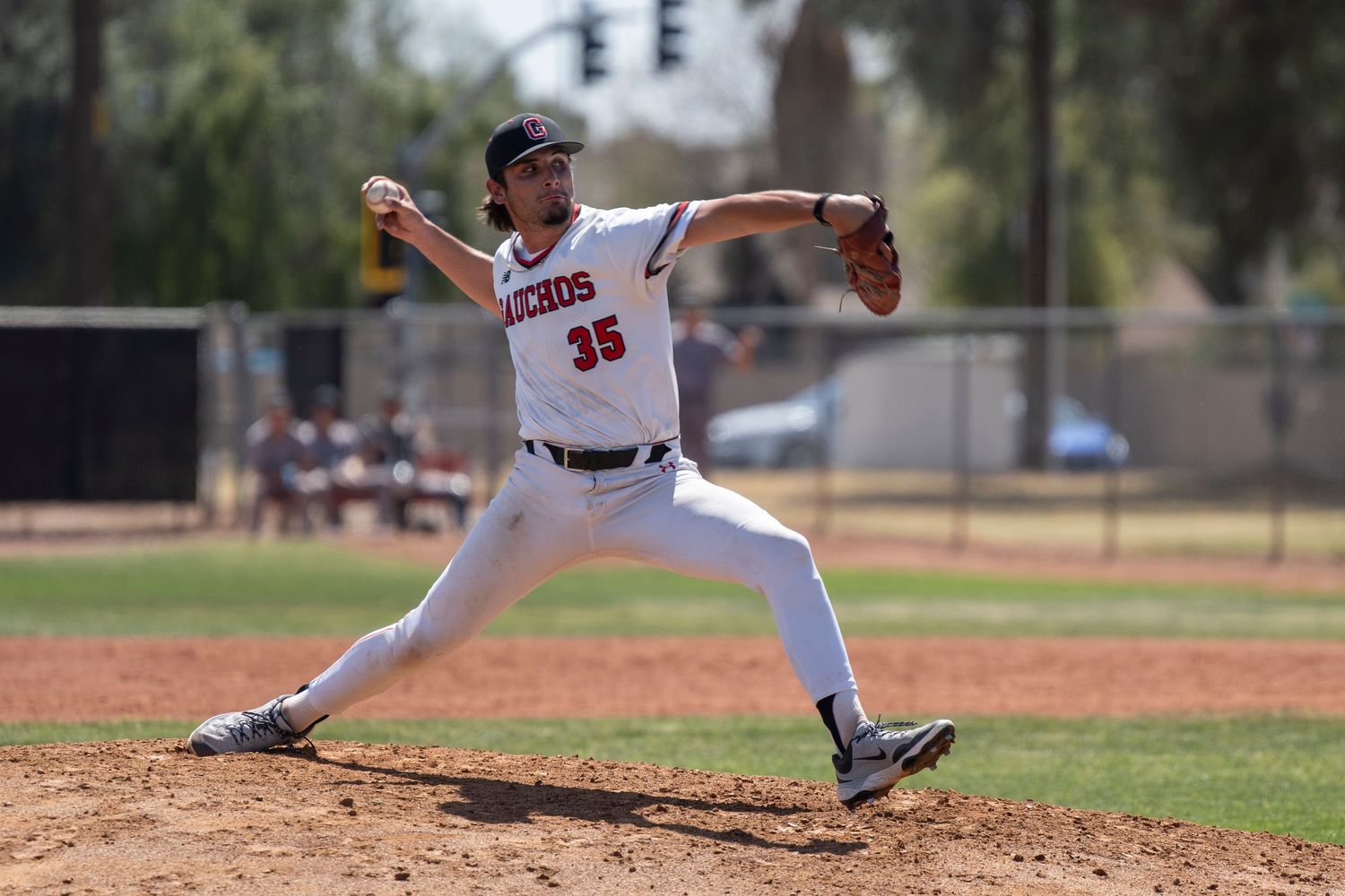 Pitcher who is lunging forward and about to throw the baseball.