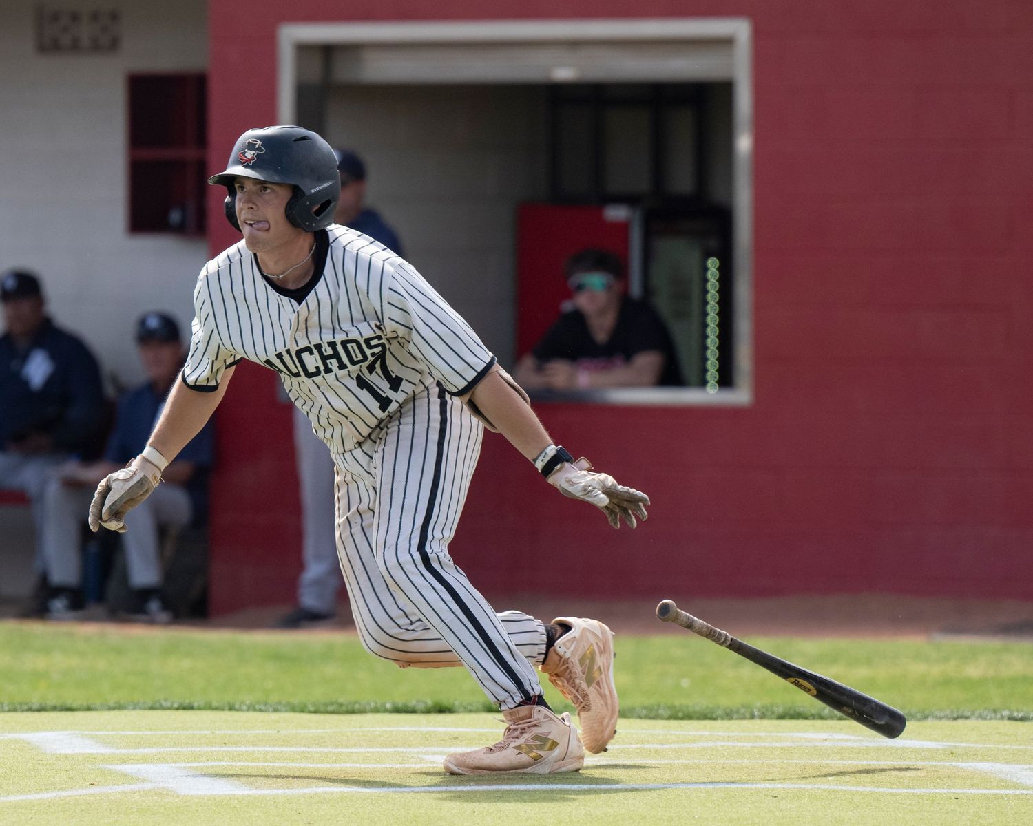 Baseball player who just batted and is dropping the bat getting ready to run.