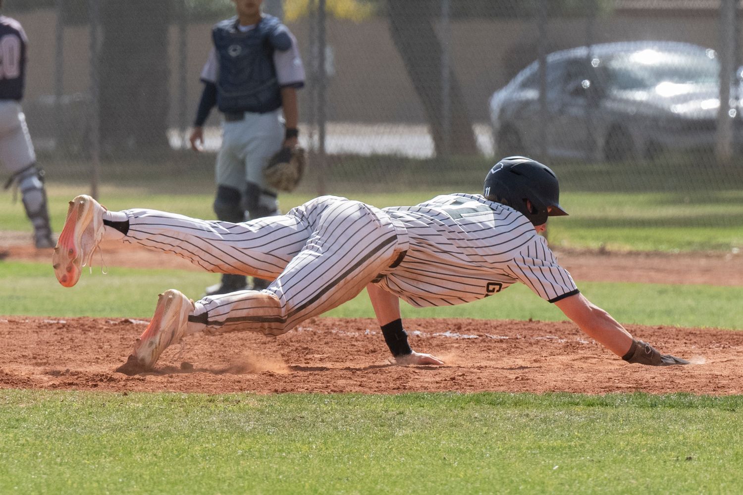 Baseball player diving to first base.