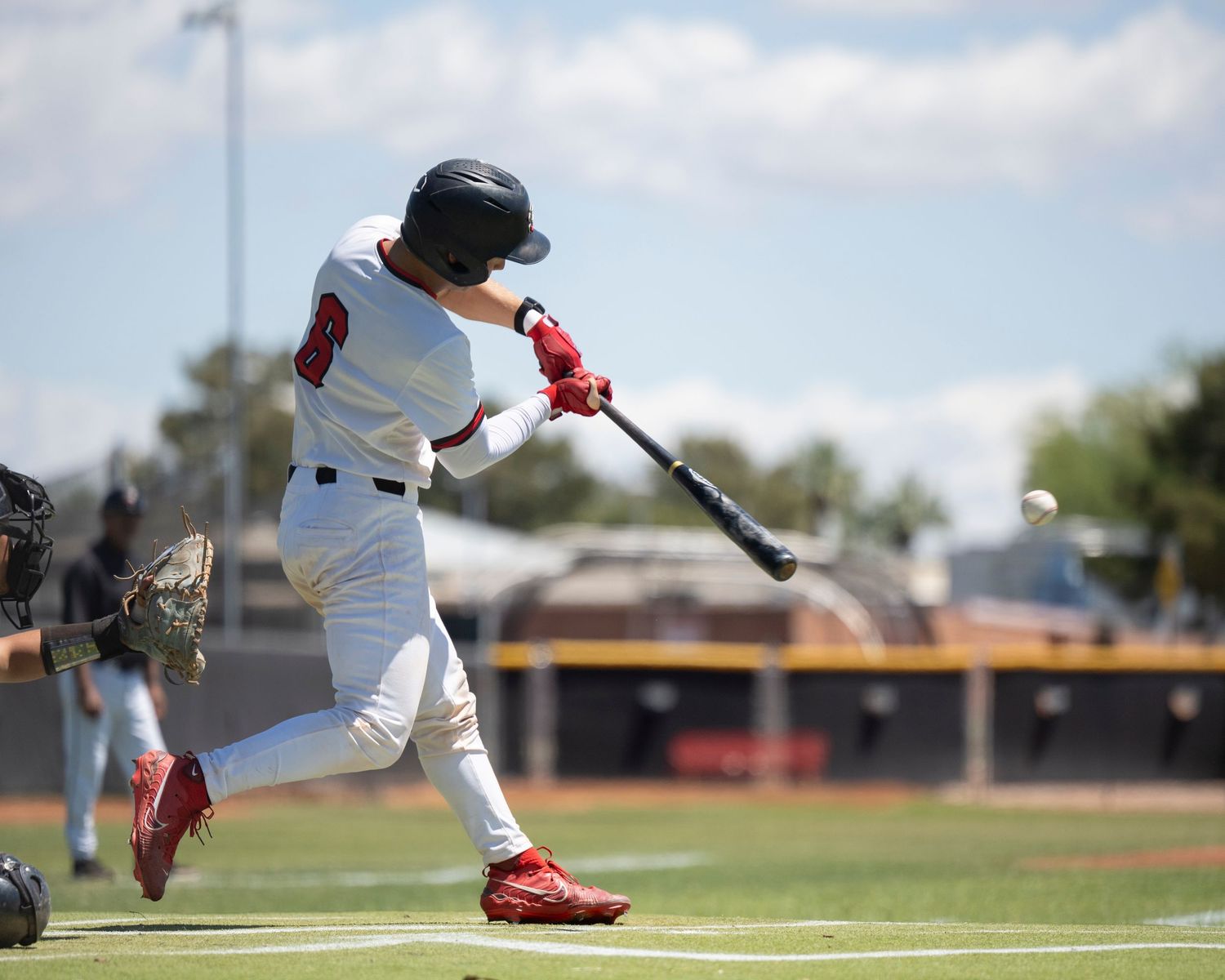 Baseball player hitting a ball.