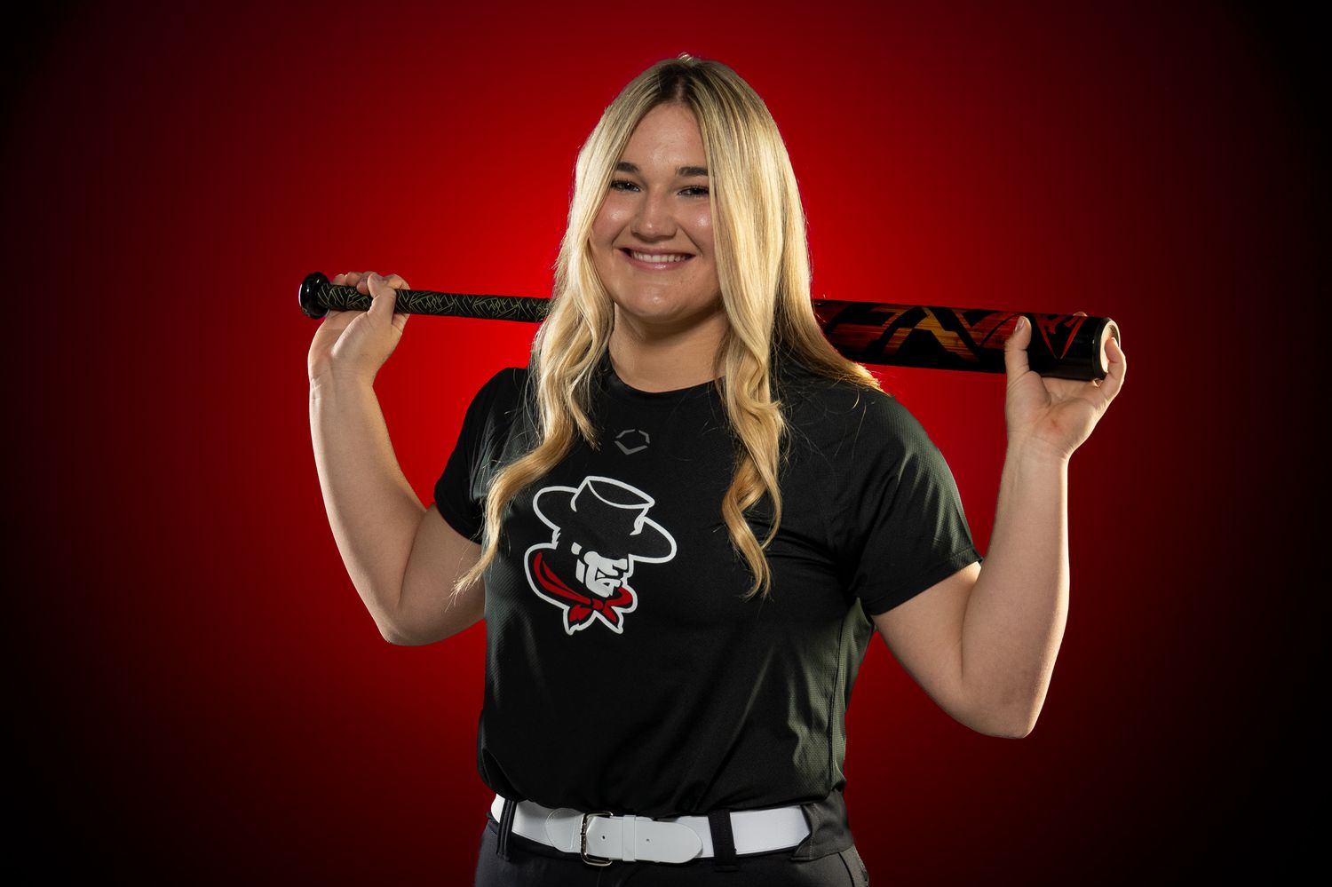 Softball player posing with a bat.