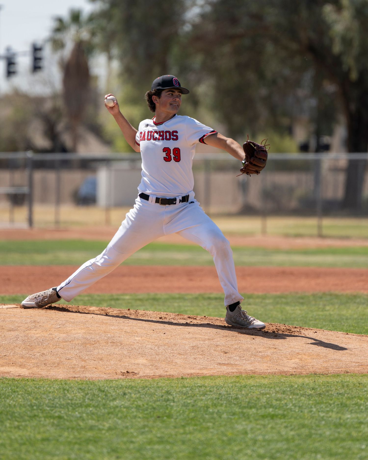 Pitcher who is lunging forward and about to throw the baseball.