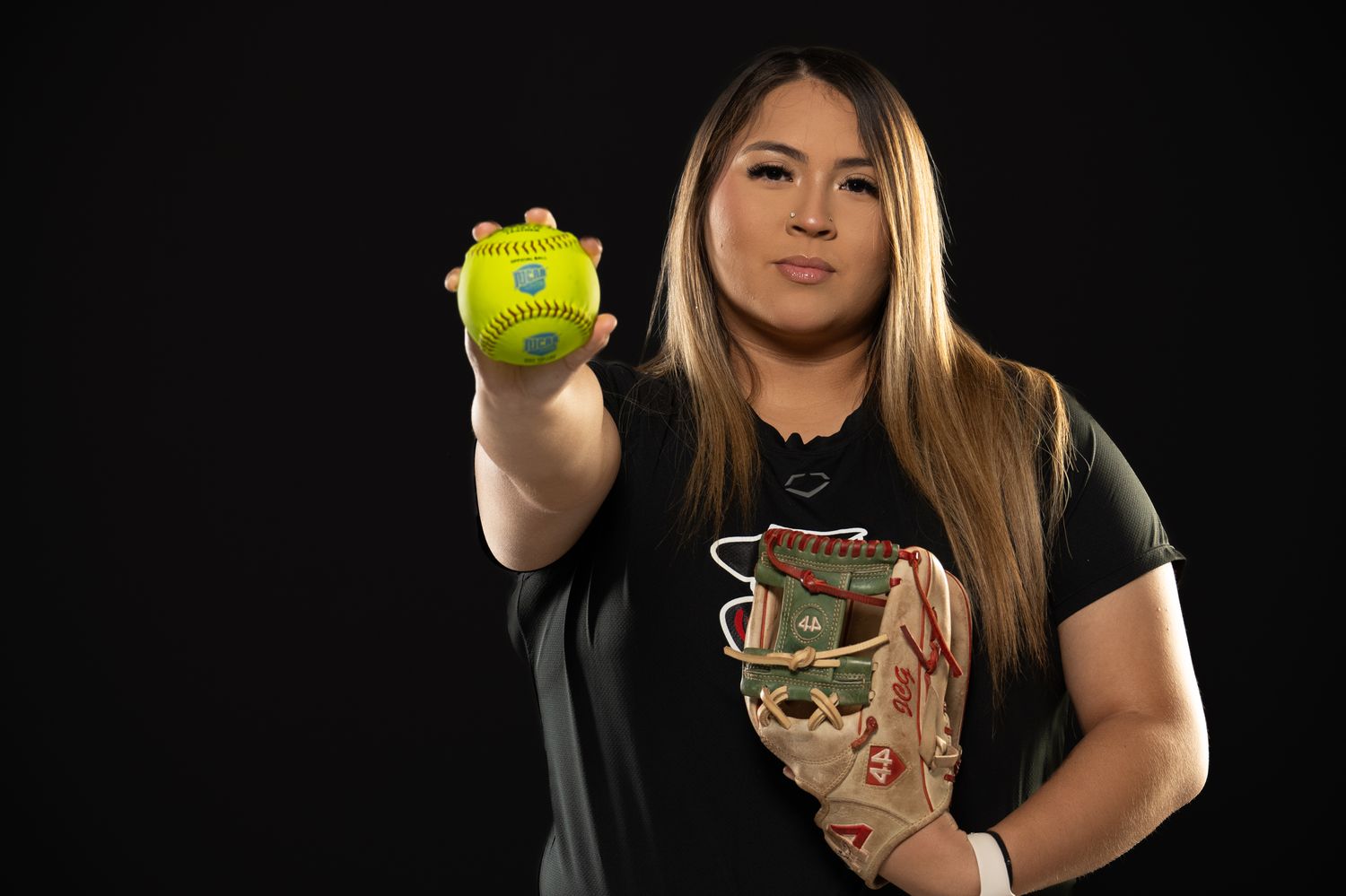 Softball player posing with a softball.