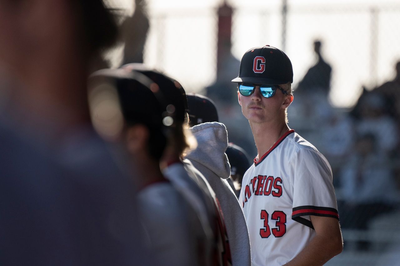 GCC Baseball player in dugout with his teammates.