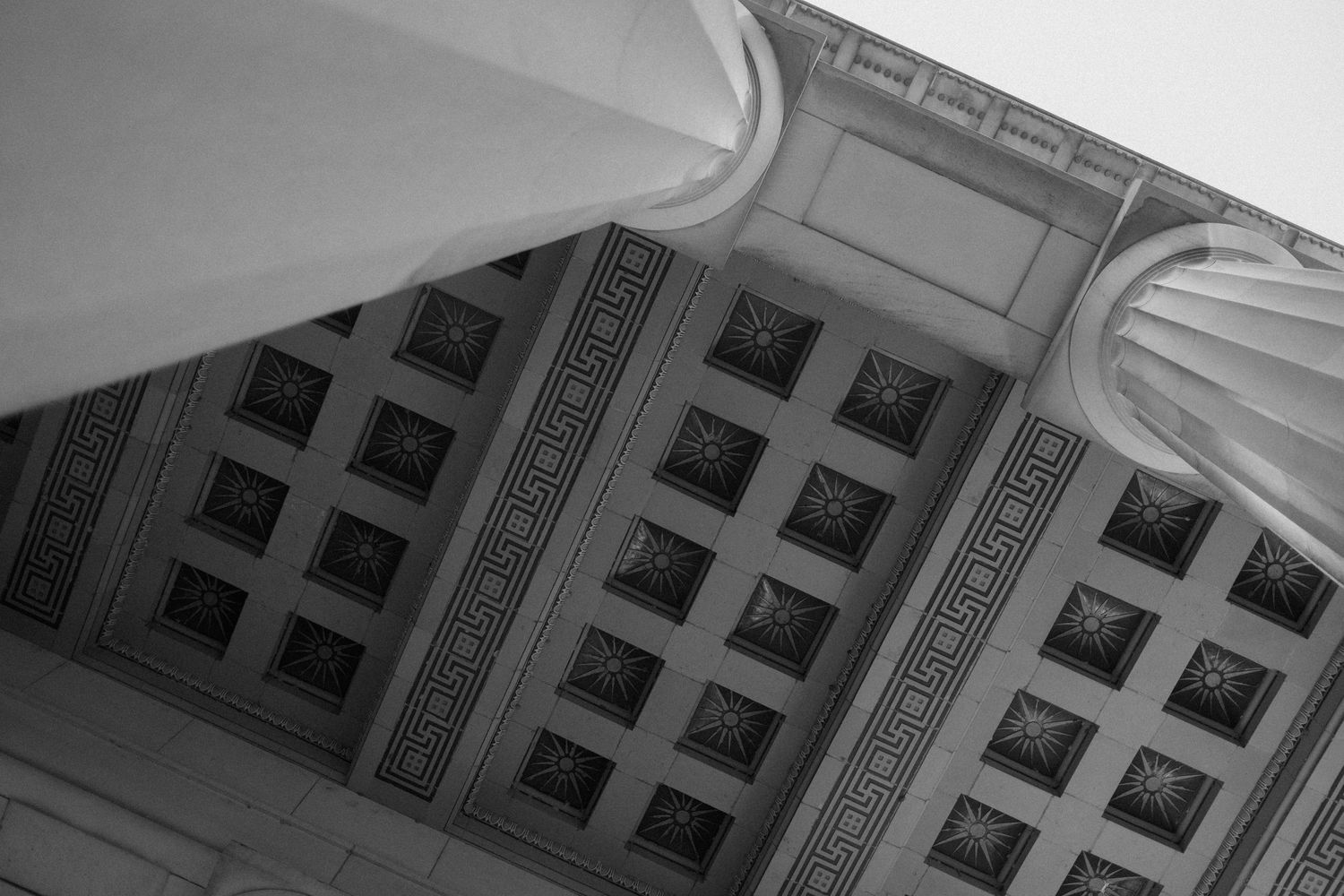 An architectural detail shot of an ornate coffered ceiling in black and white.