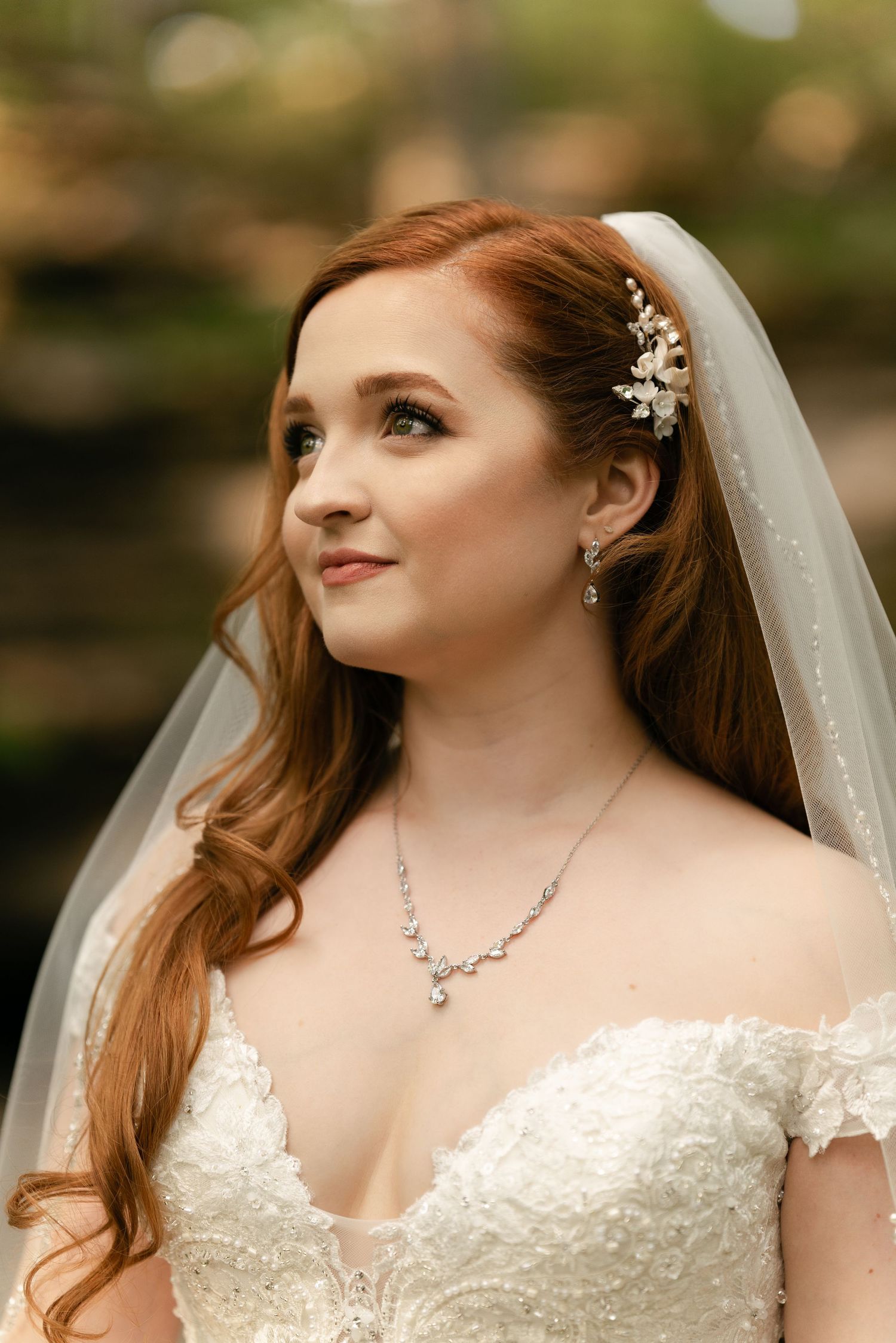 Close-up bridal portrait featuring elegant jewelry, soft makeup and flowing veil.