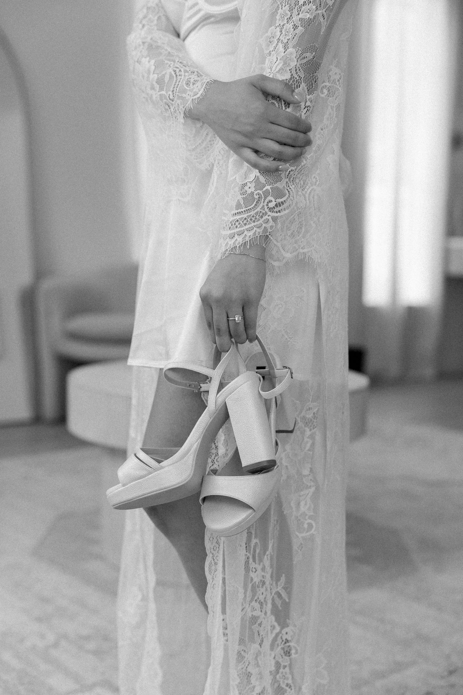 Detail shots of elegant white bridal shoes and lace wedding dress hem.