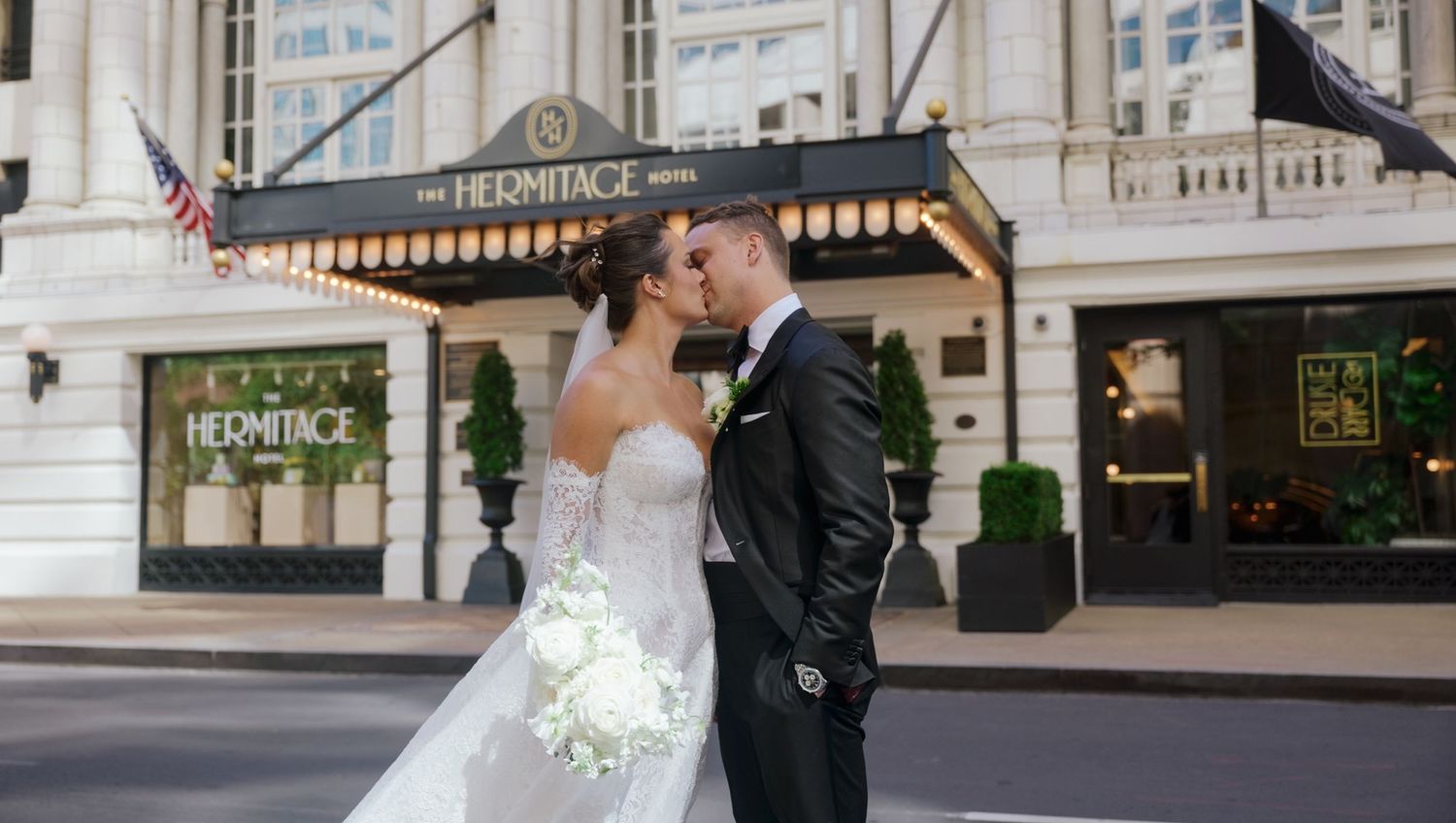 A romantic wedding couple shares a kiss outside The Providence hotel in downtown Providence, Rhode Island.