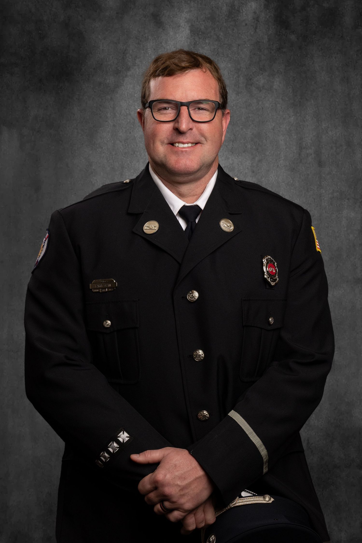 Headshot of member of non-profit, TN Professional Firefighters Assoc. on virtual background, professional and friendly.