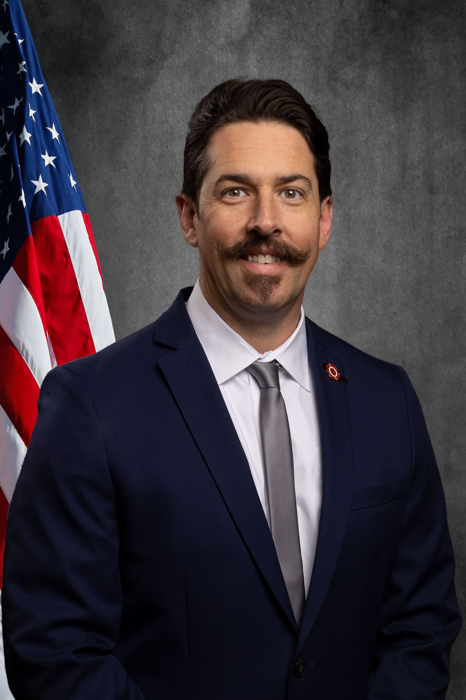 Non-profit headshot for member of Tennessee Professional Firefighters Association on virtual background with flag.