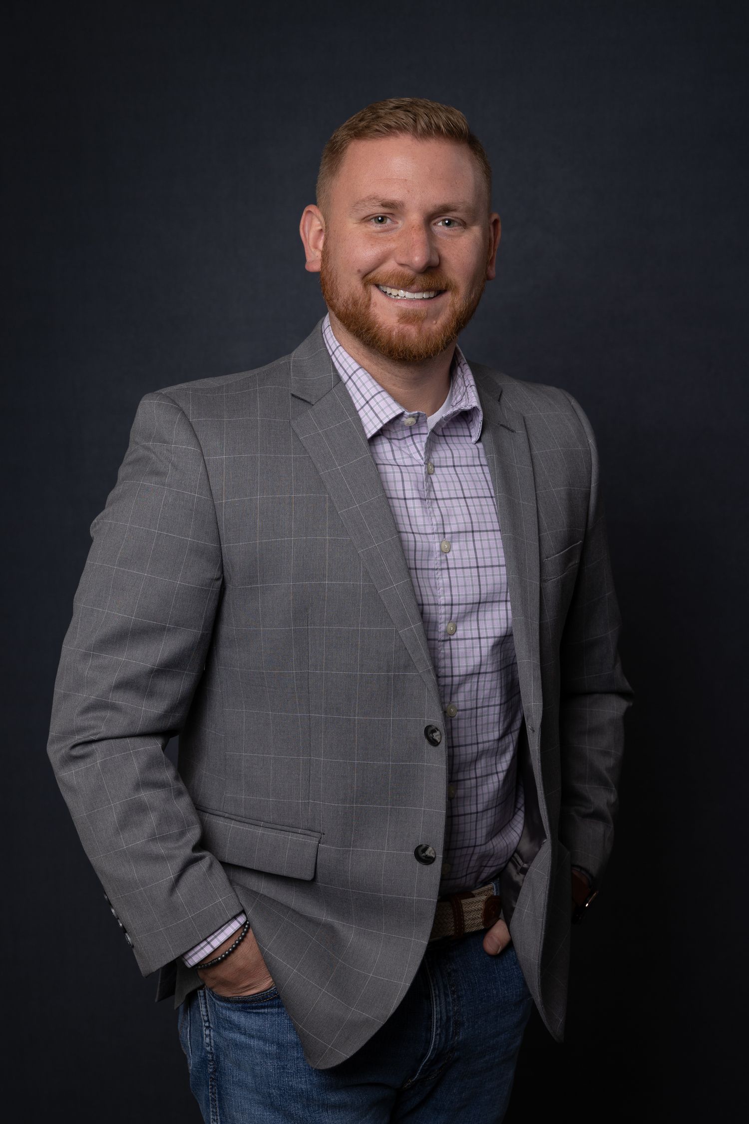 Portrait of team member at Quality Uptime, modern with personable expression, photographed under natural studio light.