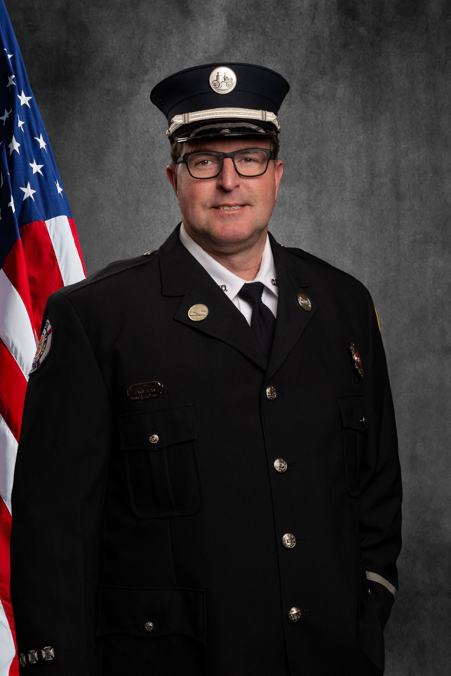 Headshot of member of non-profit, TN Professional Firefighters Assoc. on virtual background, professional and in uniform.