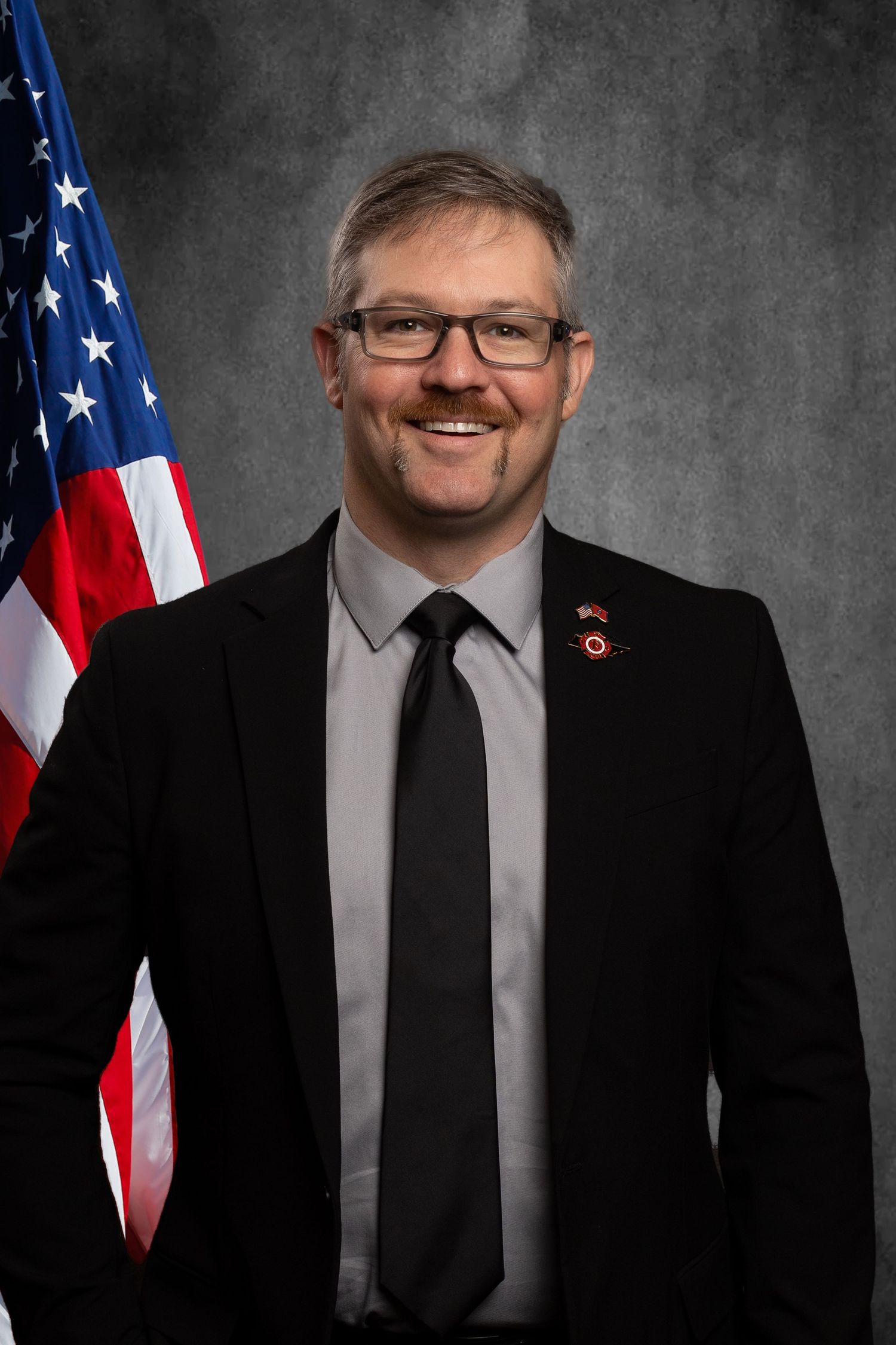 Non-profit headshot for fire fighter of TPFFA on virtual background with virtue American flag design.