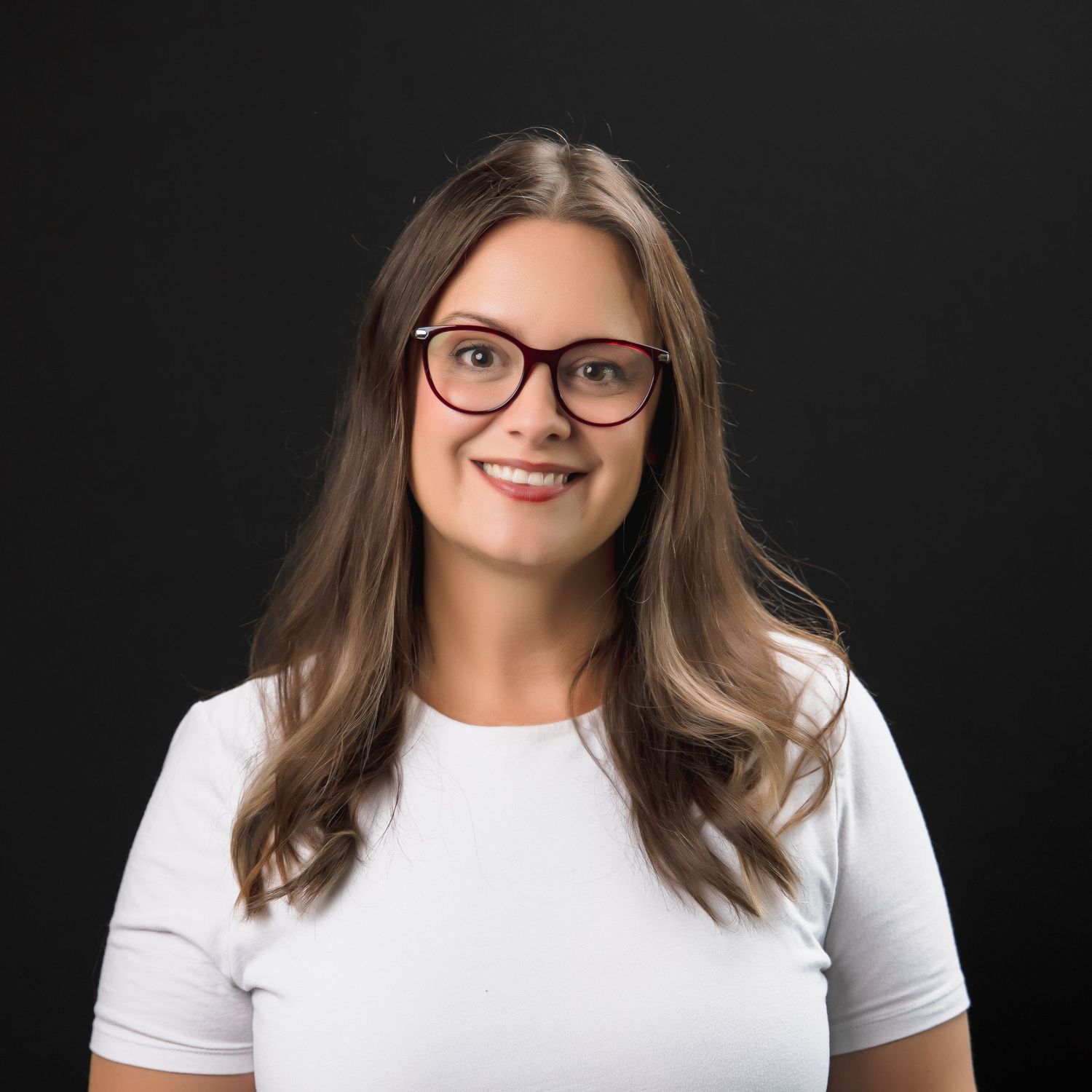 Professional headshot for sales rep at 31Digital, smiling confidently against black backdrop under bright studio lighting.