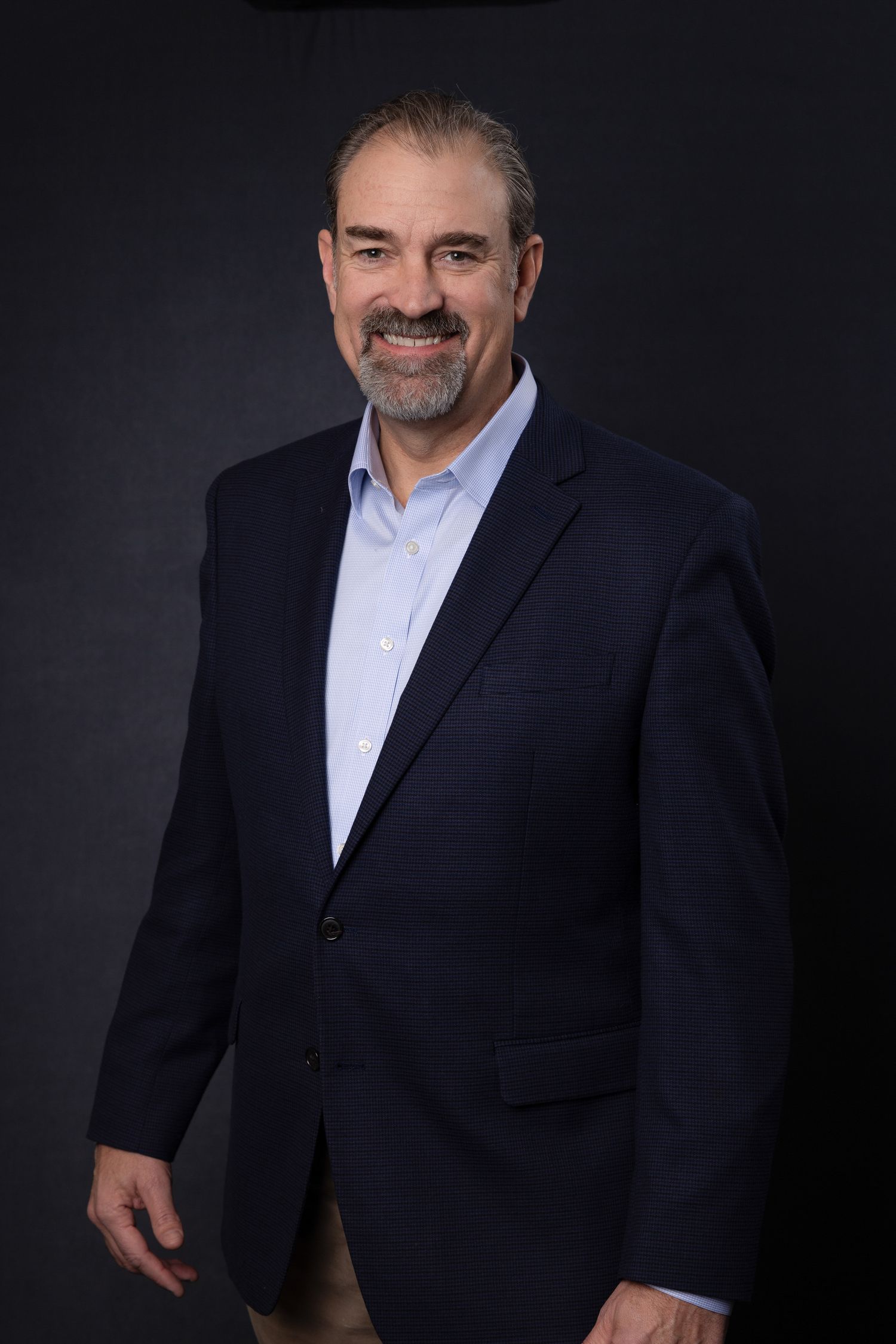 Portrait of team member at Quality Uptime, friendly and personable expression, photographed under natural studio light.