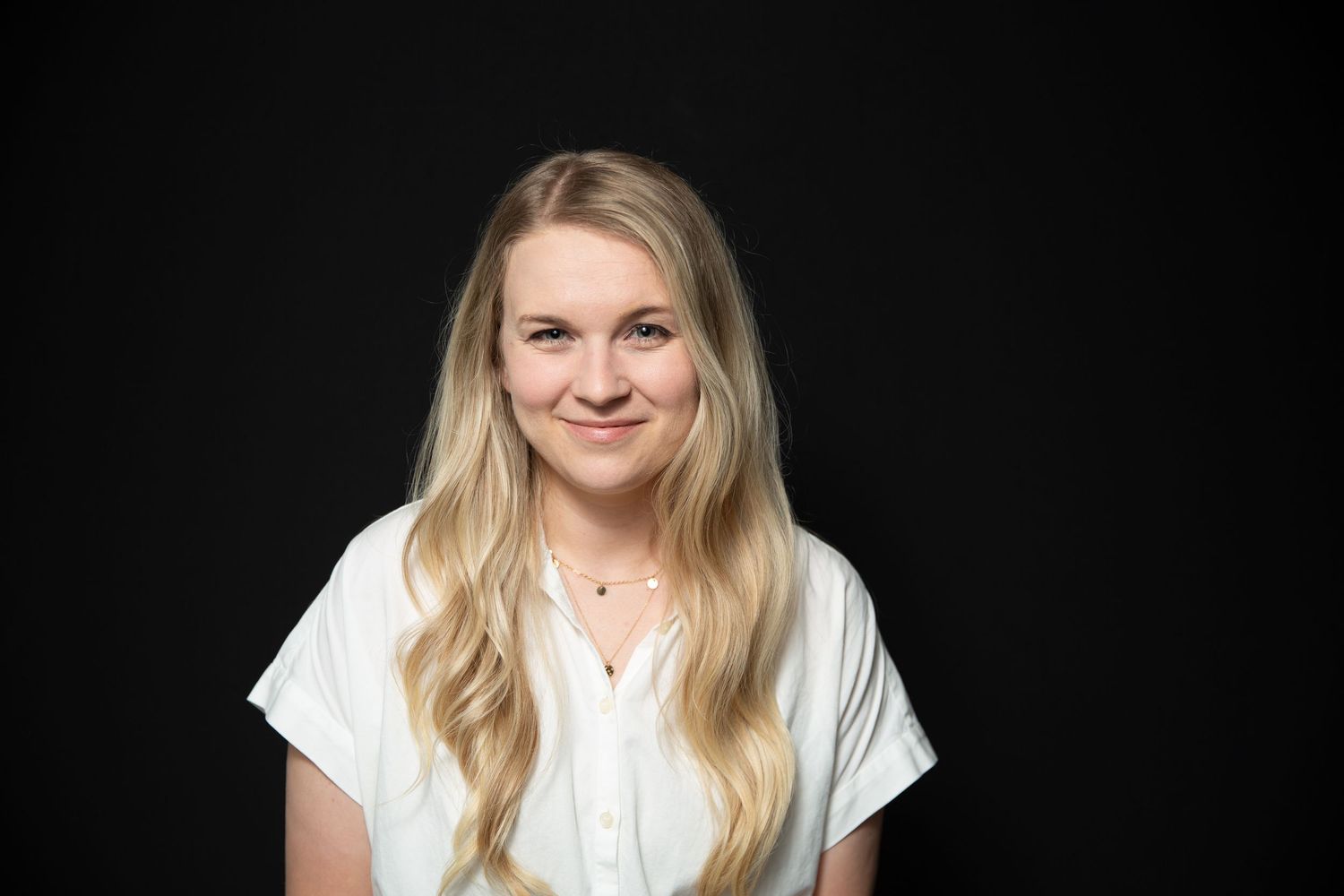 Professional headshot at 31Digital, professionally and confidently against black backdrop under bright studio lighting.