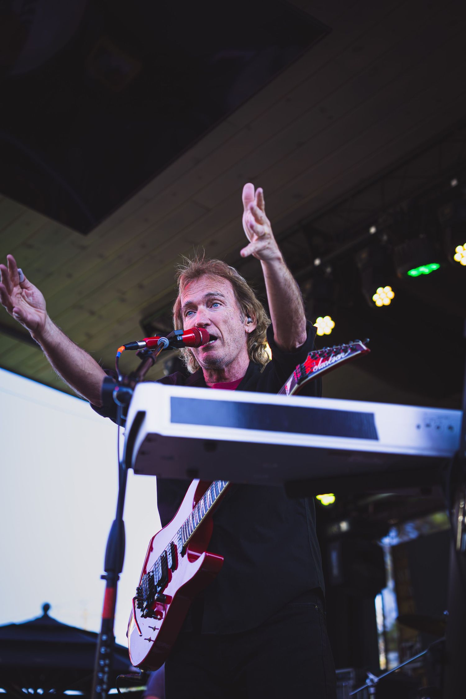 Singer on stage holding hands out to the crowd during performance