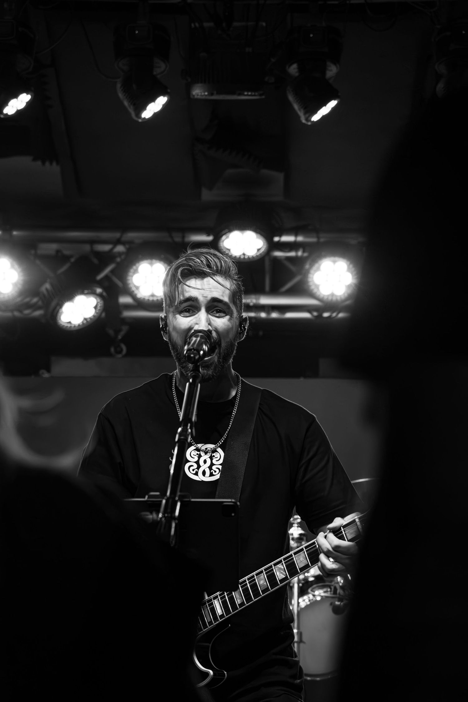 Black and white photo of guitarist singing on stage