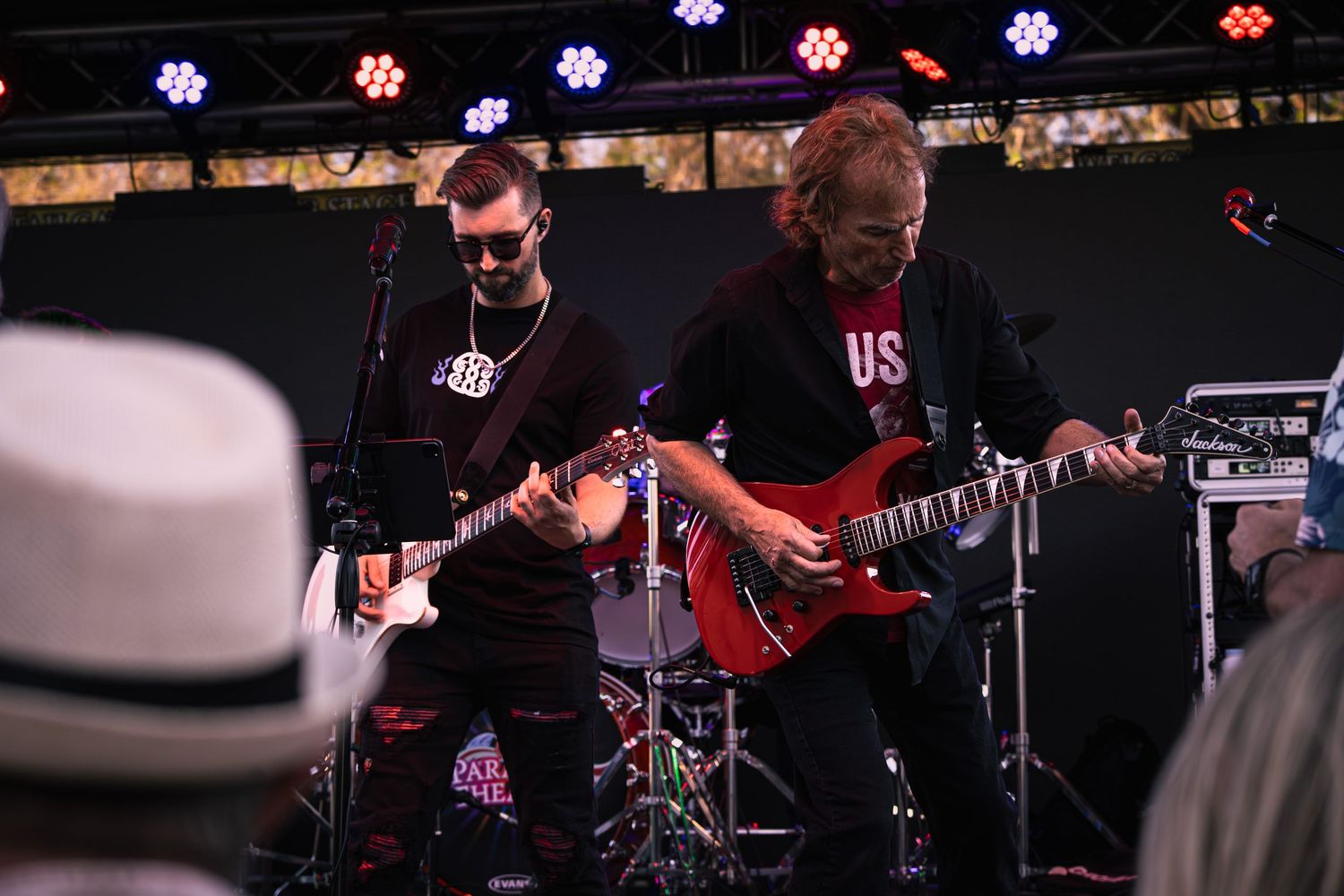 Two guitarists wearing all black during a concert