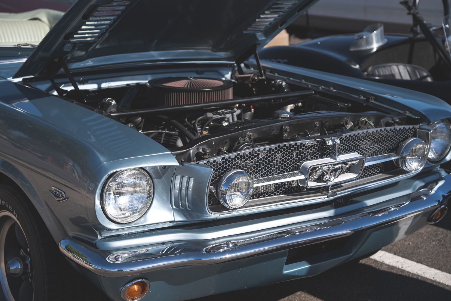Blue vintage ford mustang with the hood open