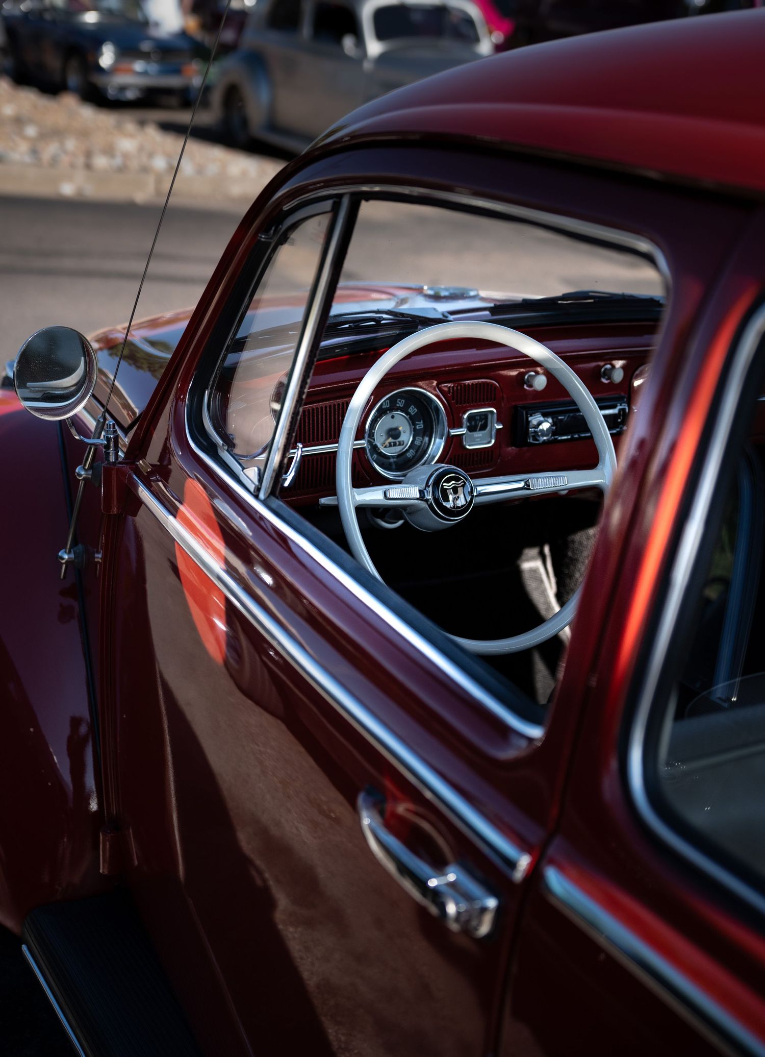 Interior of a red vintage car with a white steering wheel