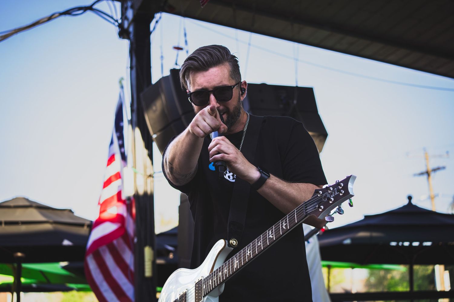 Guitarist pointing to the camera while performing during rock conert