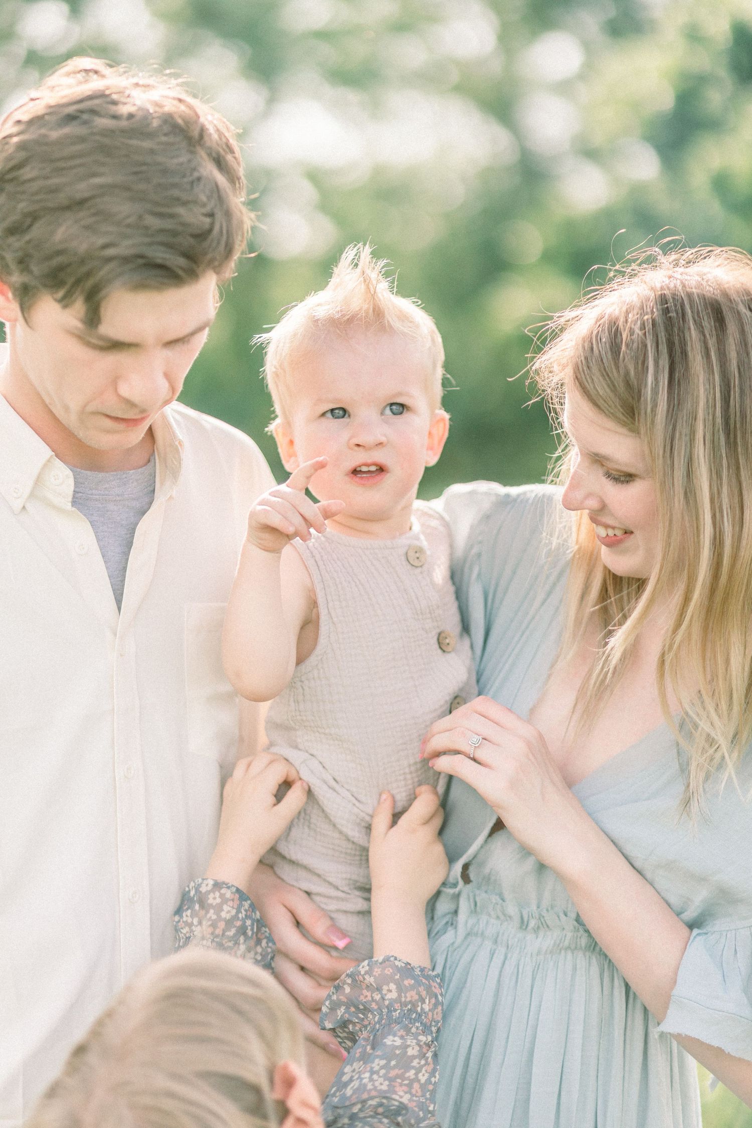 A sweet family portrait outdoors with light blue and white clothing captured in soft natural light in Springfield, Missouri.
