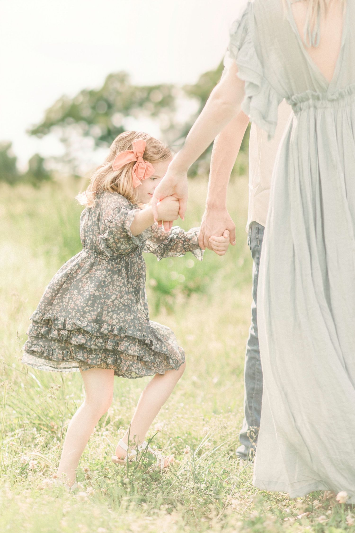A series of candid shots showing playful moments between parent and child in a sunlit meadow with tall grass.