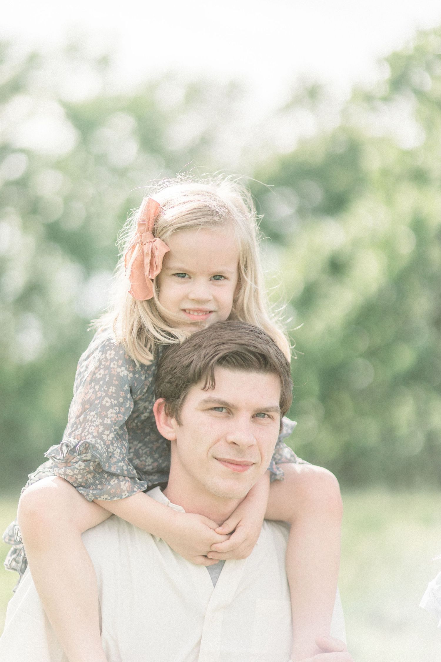 A sweet candid portrait of a child perched on shoulders in a bright summer field at Fellows Lake in Springfield, Missouri.
