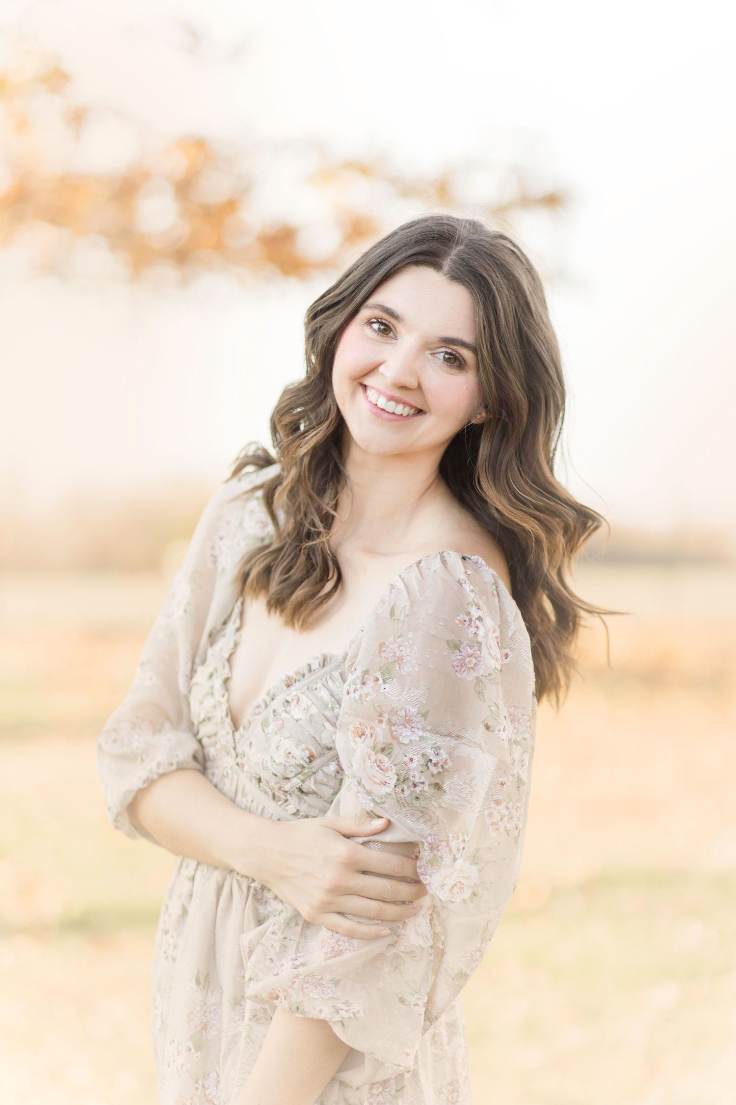 A dreamy portrait in soft beige tones showing a floral dress against a warm background in Springfield, Missouri.