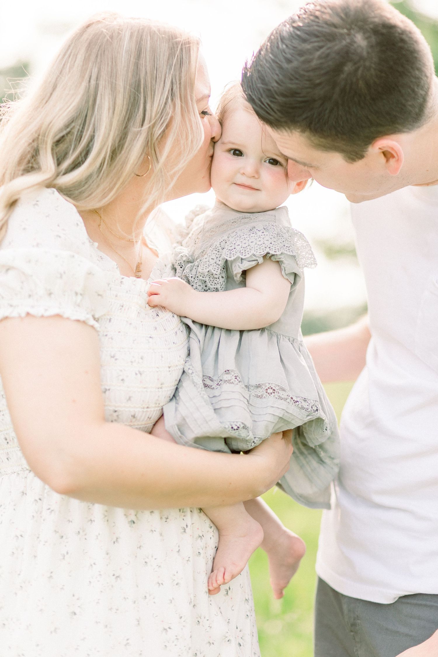 Intimate outdoor family photo sequence showing parents embracing their young child against a bright natural backdrop in Springfield, MO.