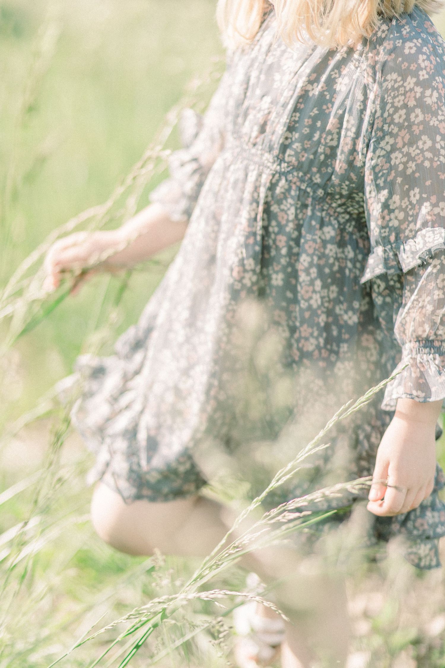 Detail of a floral dress blowing in the breeze among tall summer grasses at Fellows Lake in Springfield, Missouri.