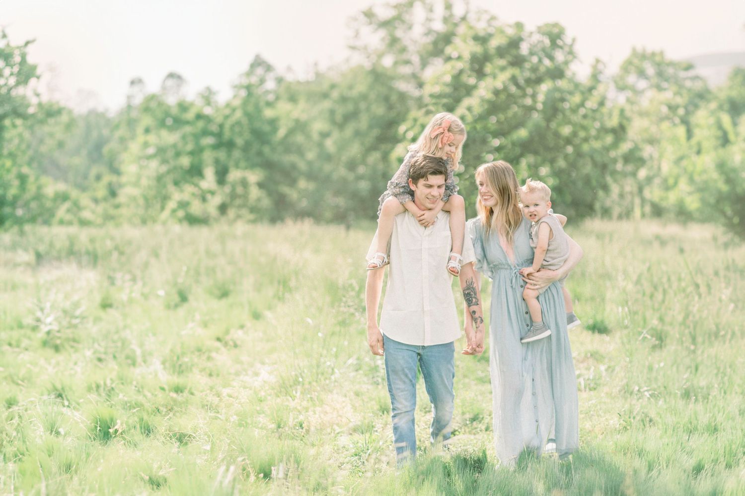 Family walking together through a sunlit Fellows Lake meadow on a peaceful summer day in Springfield, Missouri.