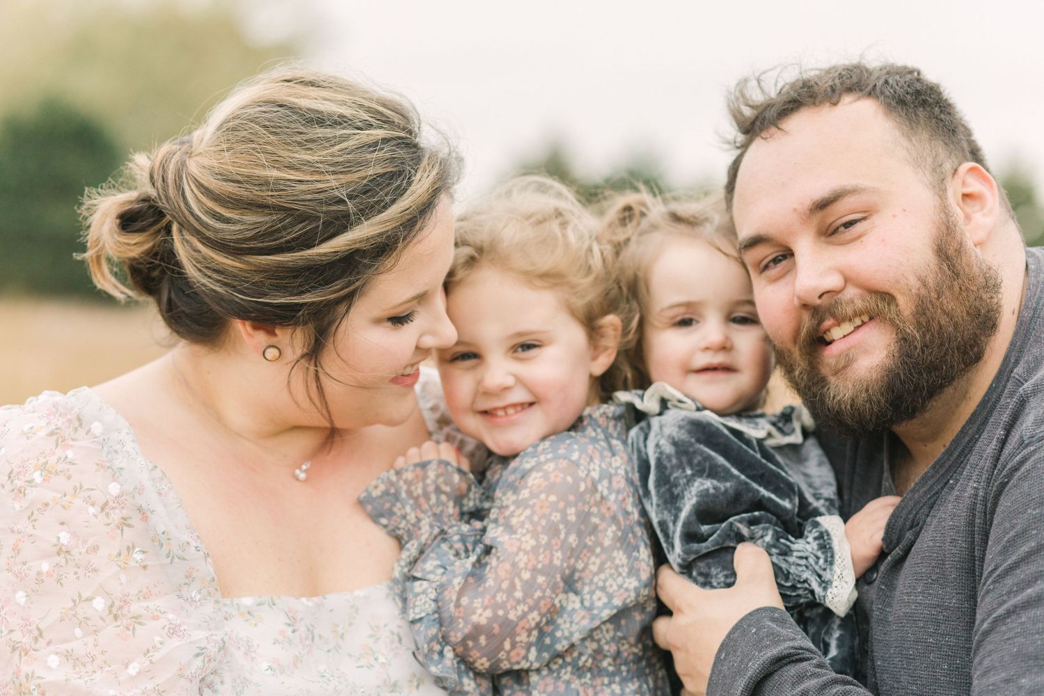 A close-up of a smiling family of four during their Springfield, MO family photography session with Shelby Speak Photography.