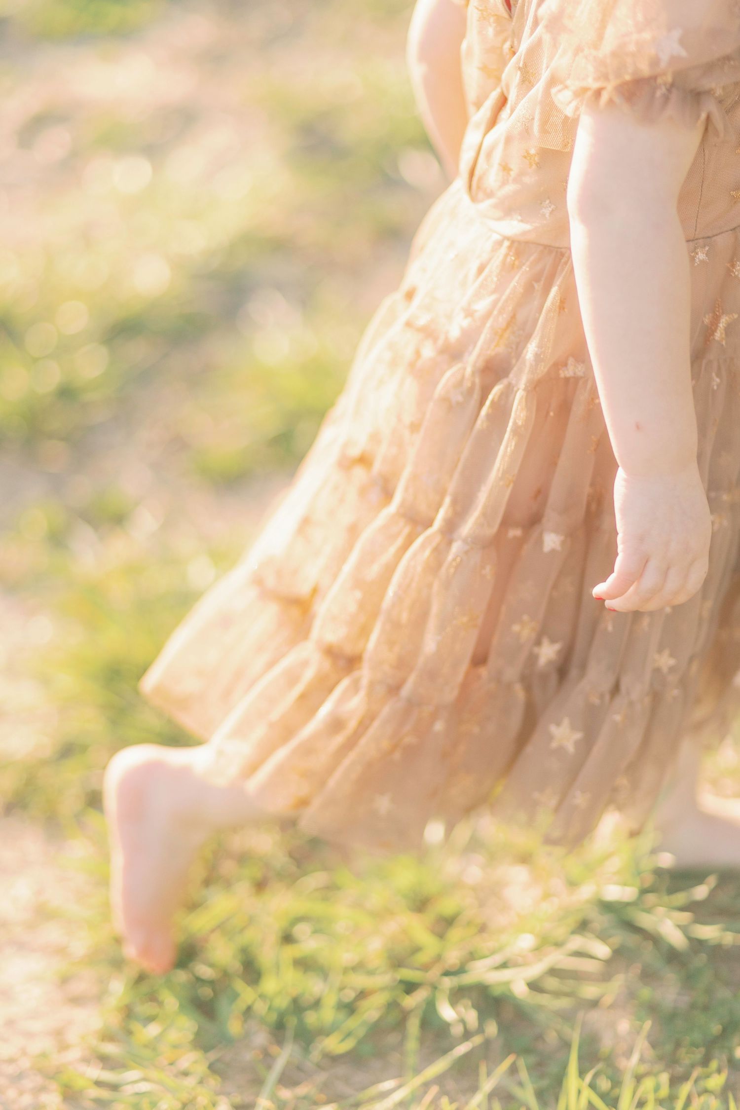 Flowing peach-colored tulle dress movement captured in dreamy sunlit outdoor setting in Marshfield, MO.